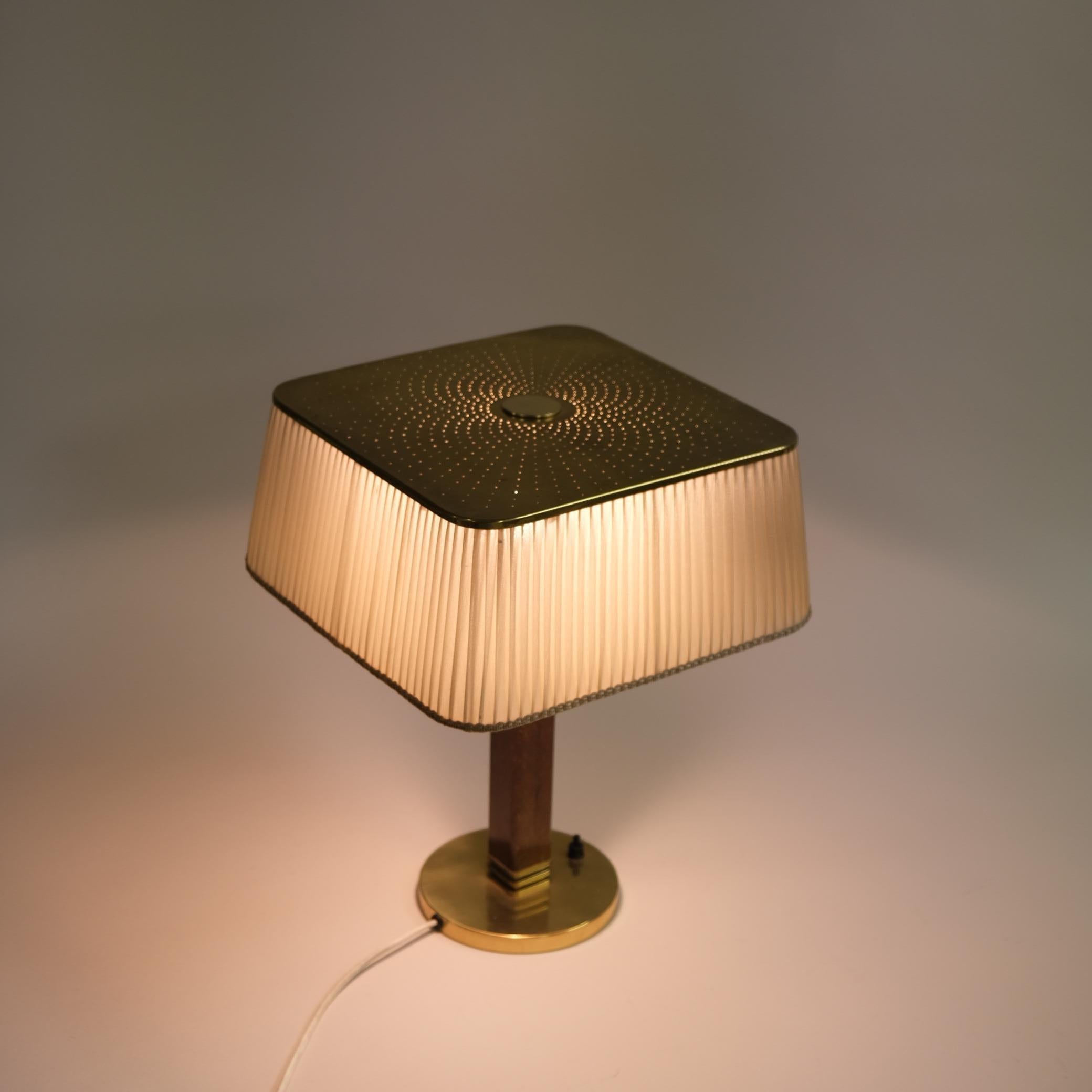 Tischleuchte Modell 5066, entworfen von Paavo Tynell und hergestellt von Taito Oy in Finnland in den 1950er Jahren. Die Lampe verfügt über einen runden Ständer aus Messing, ein hartes Holzbein und einen schönen leichten Seidenschirm. Der