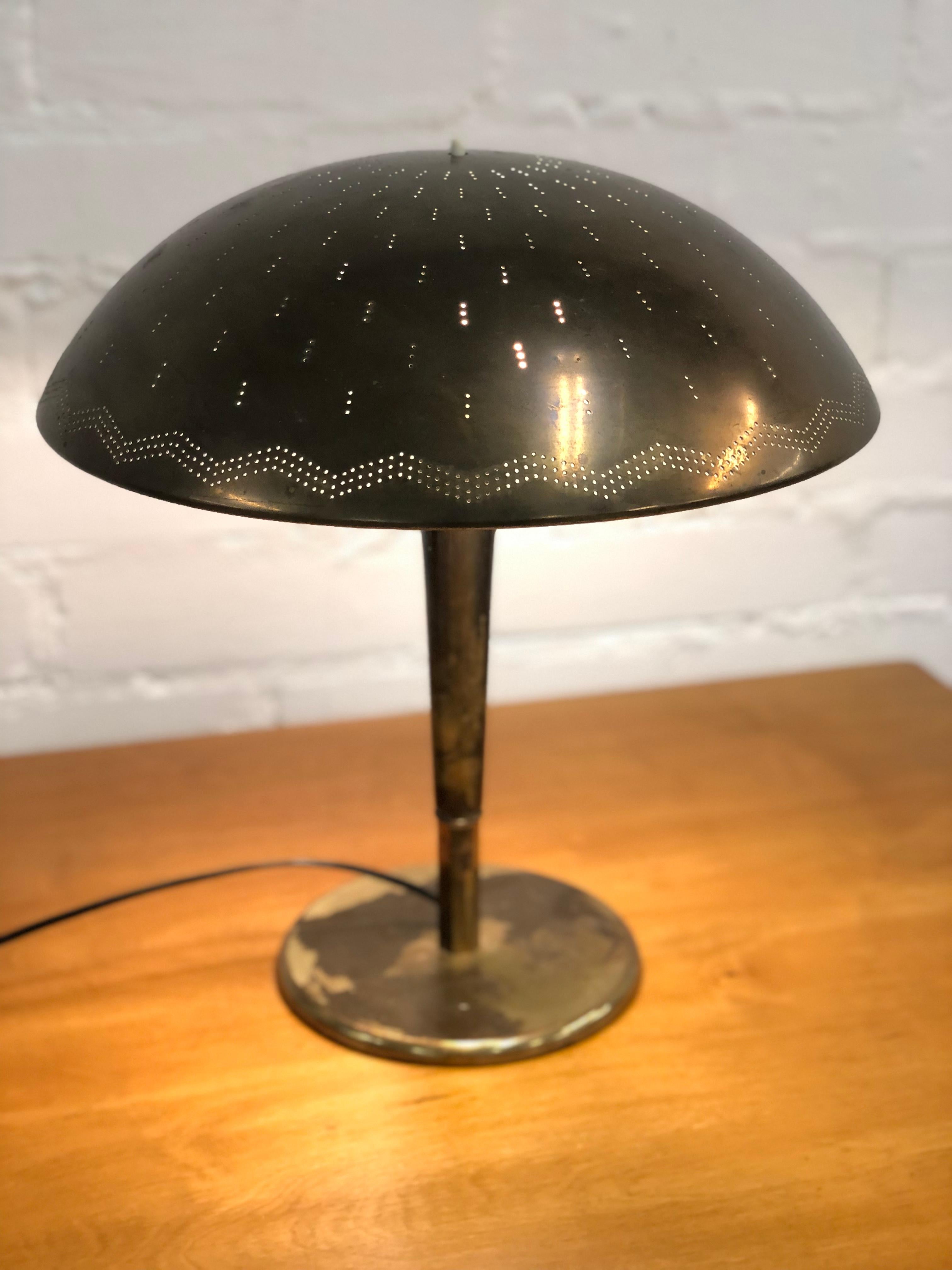 A beautiful Paavo Tynell table lamp model 5061 in full brass and very heavy patina that gives the lamp a rough look. The item can be polished upon request, but we recommend you keep the beautiful and unique patina. The lamp is in full original