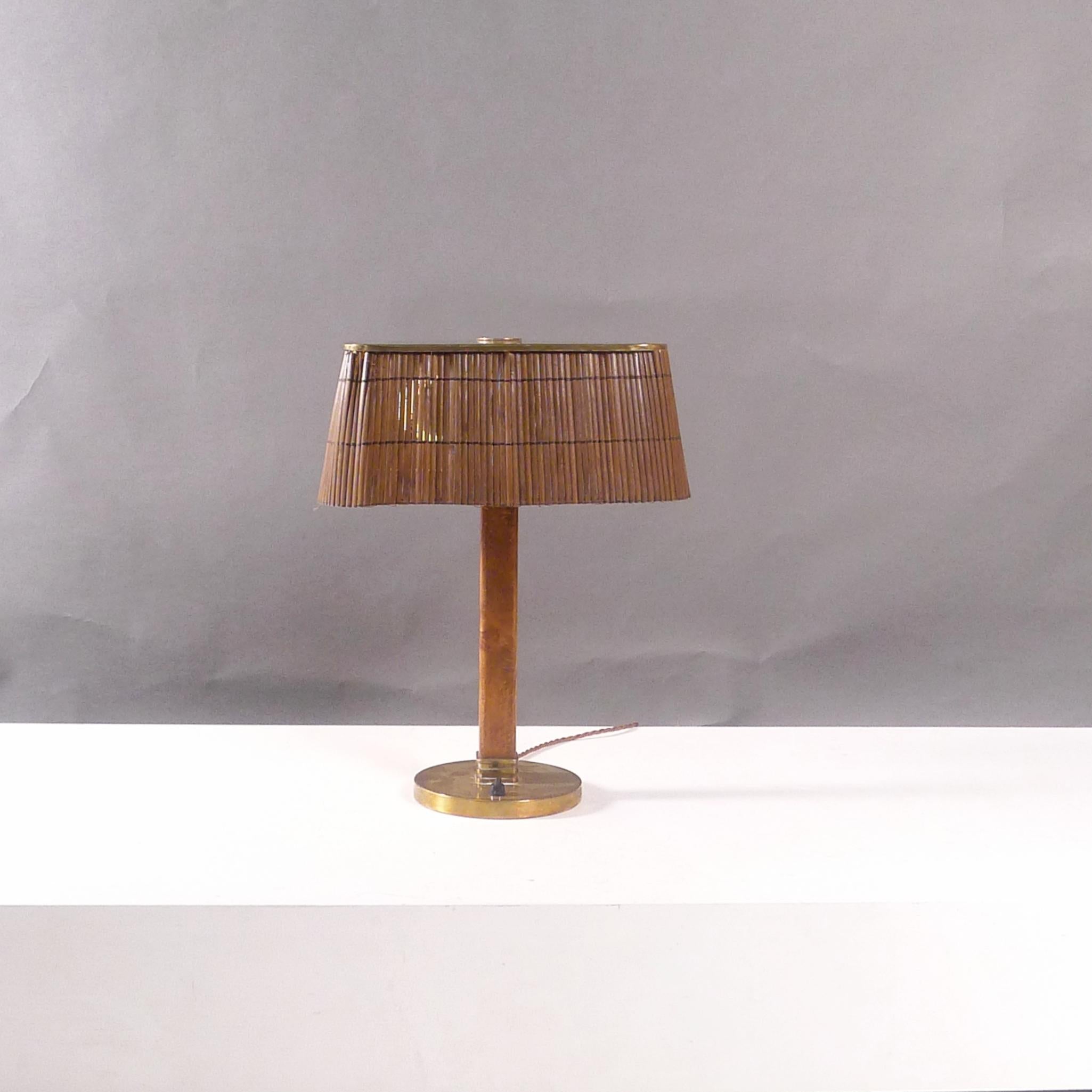 Paavo Tynell
Table Lamp, model 5066
designed circa 1940 and made by Taito Oy, Finland

Hard wood square stem with circular brass base and push button, the square rattan shade with brass top perforated in the fibonacci sequence to allow light to