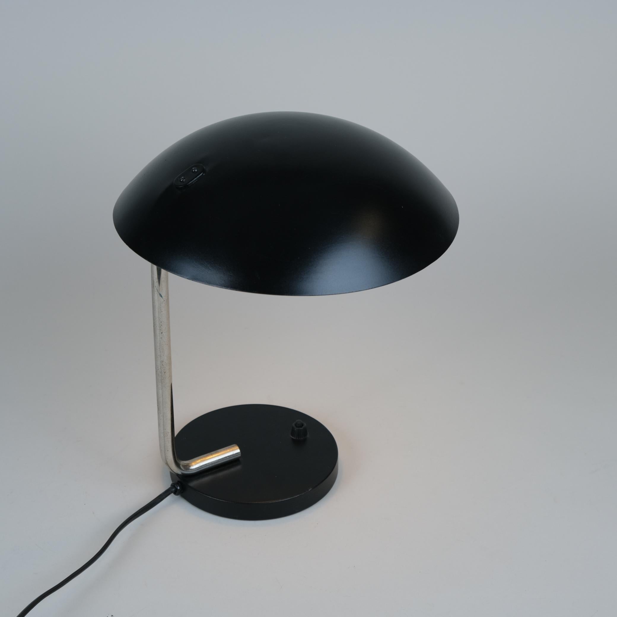 Cette lampe de table fait partie des premières lampes Tynell des années 1930 avec une influence évidente du Bauhaus. La combinaison de l'acier inoxydable et de la peinture noire distingue cette lampe des lampes en laiton courantes dans ses créations