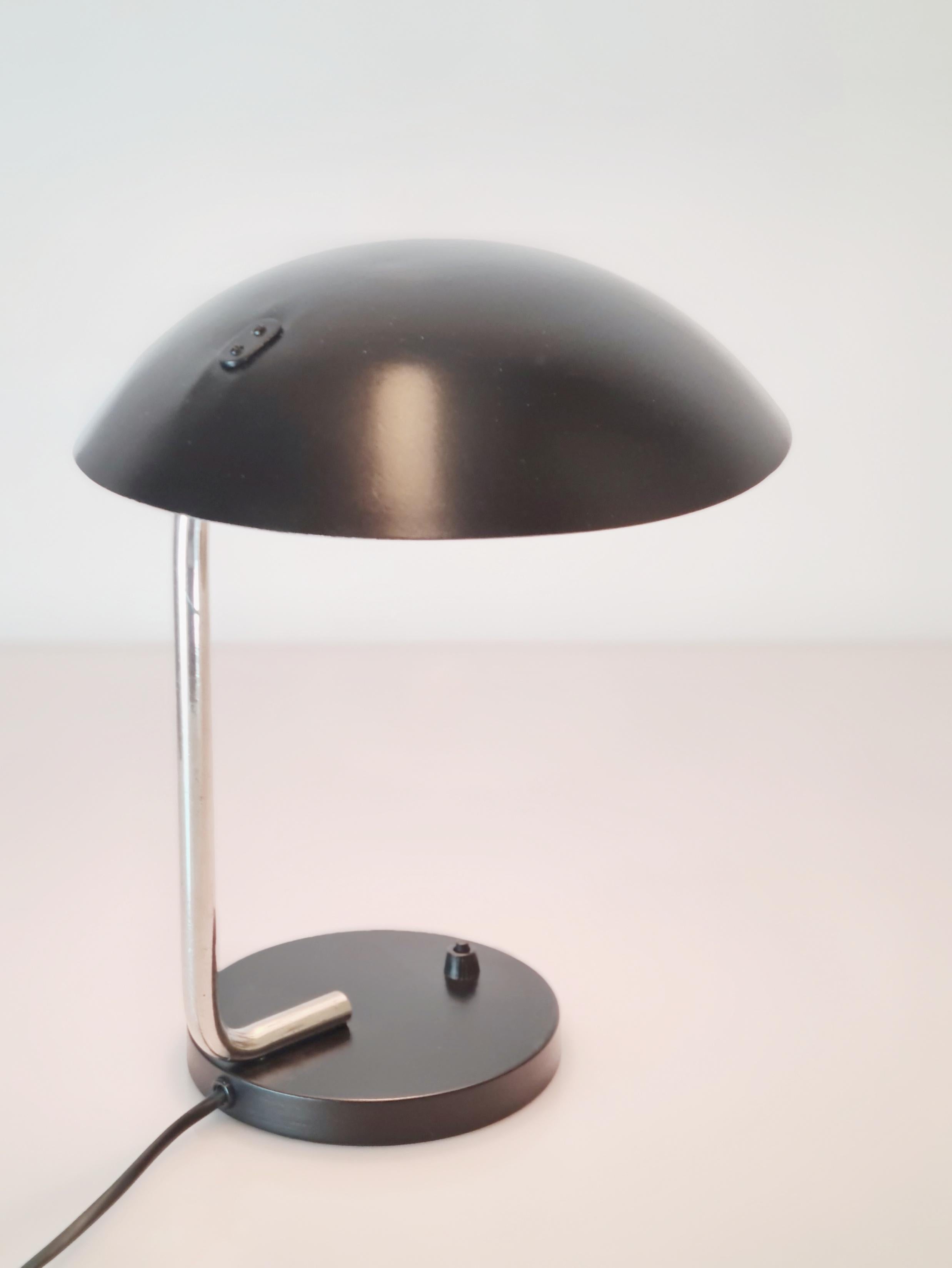 This table lamp is a part of the early Tynell lamps from the 1930s. The combination of stainless steel and black paint separates this lamp from the common brass lamps. Simple yet elegant design makes this lamp suitable for almost any decor. The lamp