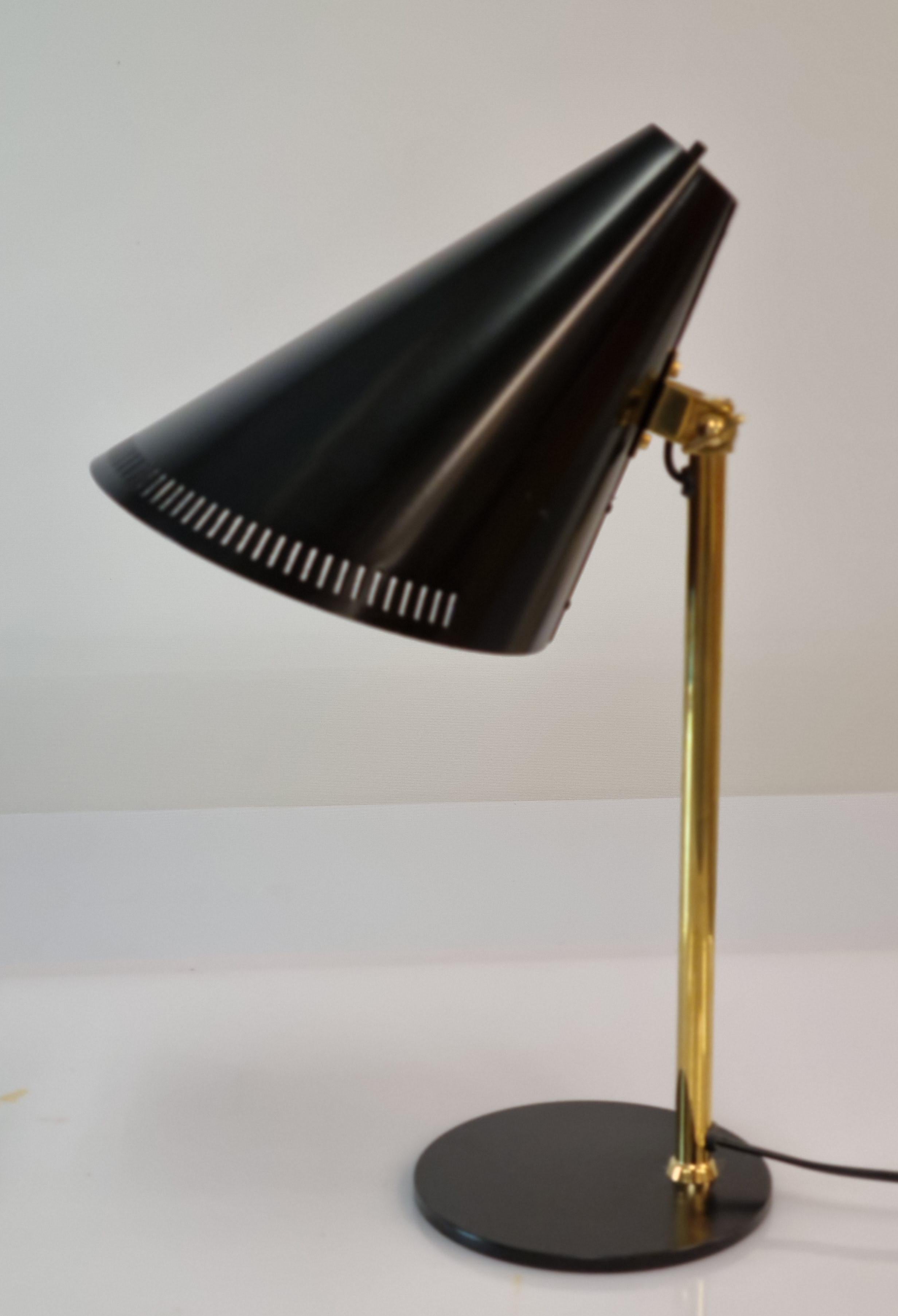 This table lamp model H5-7 by Paavo Tynell is a time lasting and practical model starting from materials. In this model firm brass stem supports aluminum cone shade. The shade is matt black and is adjustable for your needs. The light switch is on
