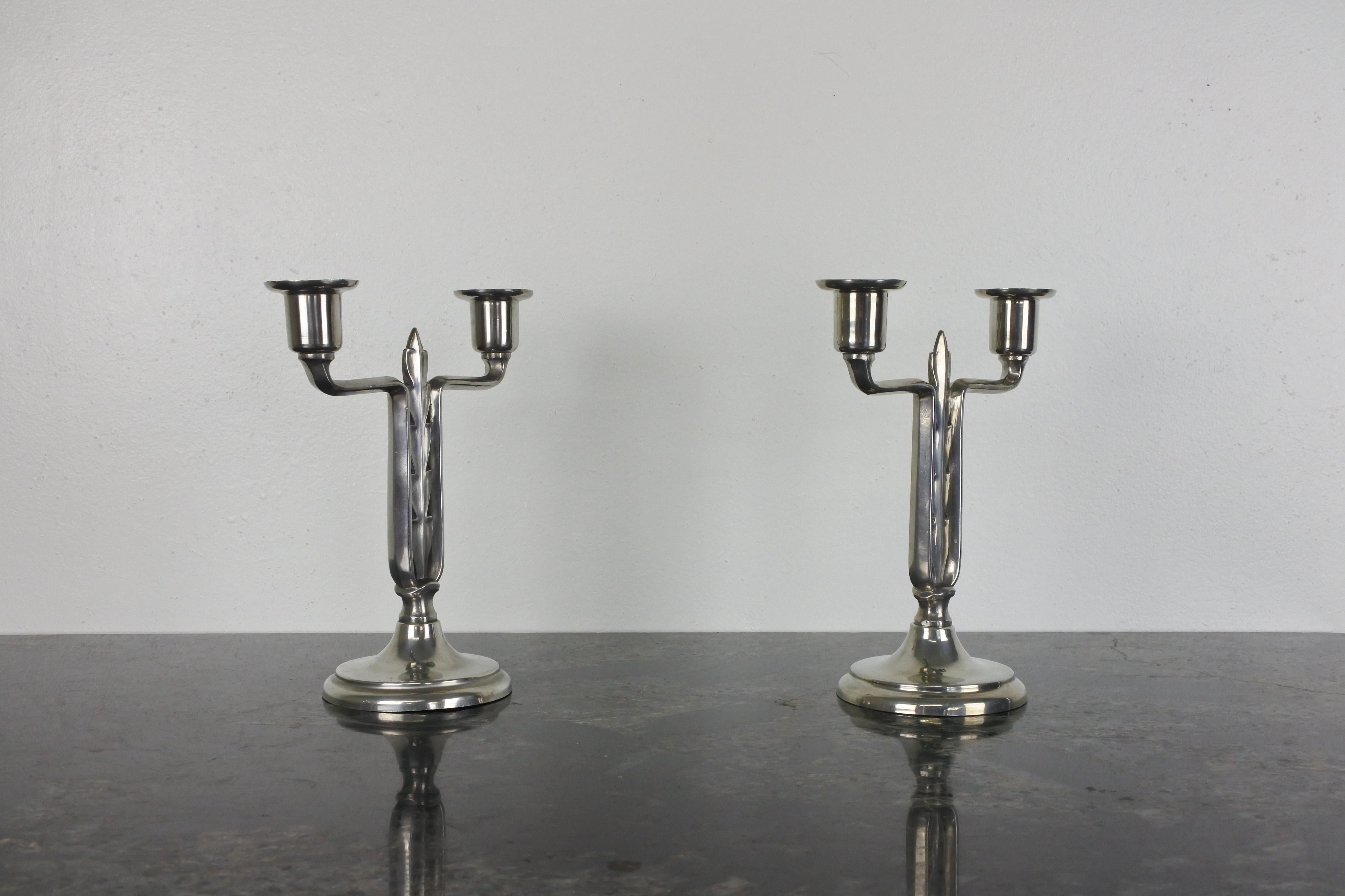 Pair of Art Deco silver plated metal candelabra by Paavo Tynell.
Model 8026.
Made in Finland by Taito in the 1930s.
Manufacturer's stamp on both.

Literature: OY Taito AB catalogue, 1933, page 51, Model number 8026.