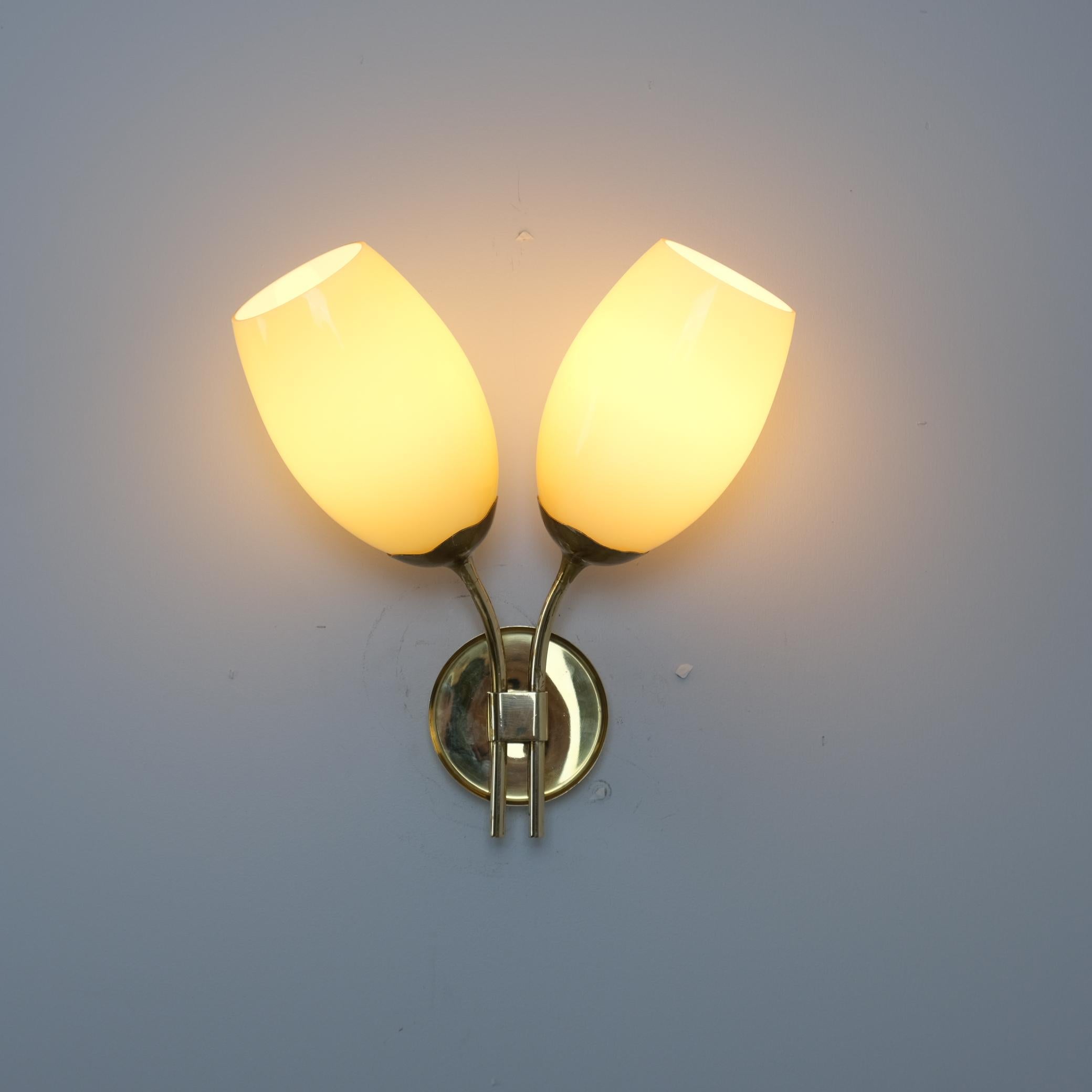 Minimalist Brass and Glass Wall Sconce (Model 9452) by Paavo Tynell for Taito Oy, Finland, 1950s

This exquisite wall lamp, Model 9452, designed by Paavo Tynell and manufactured by Taito Oy in the 1950s, exemplifies the Finnish master’s ability to