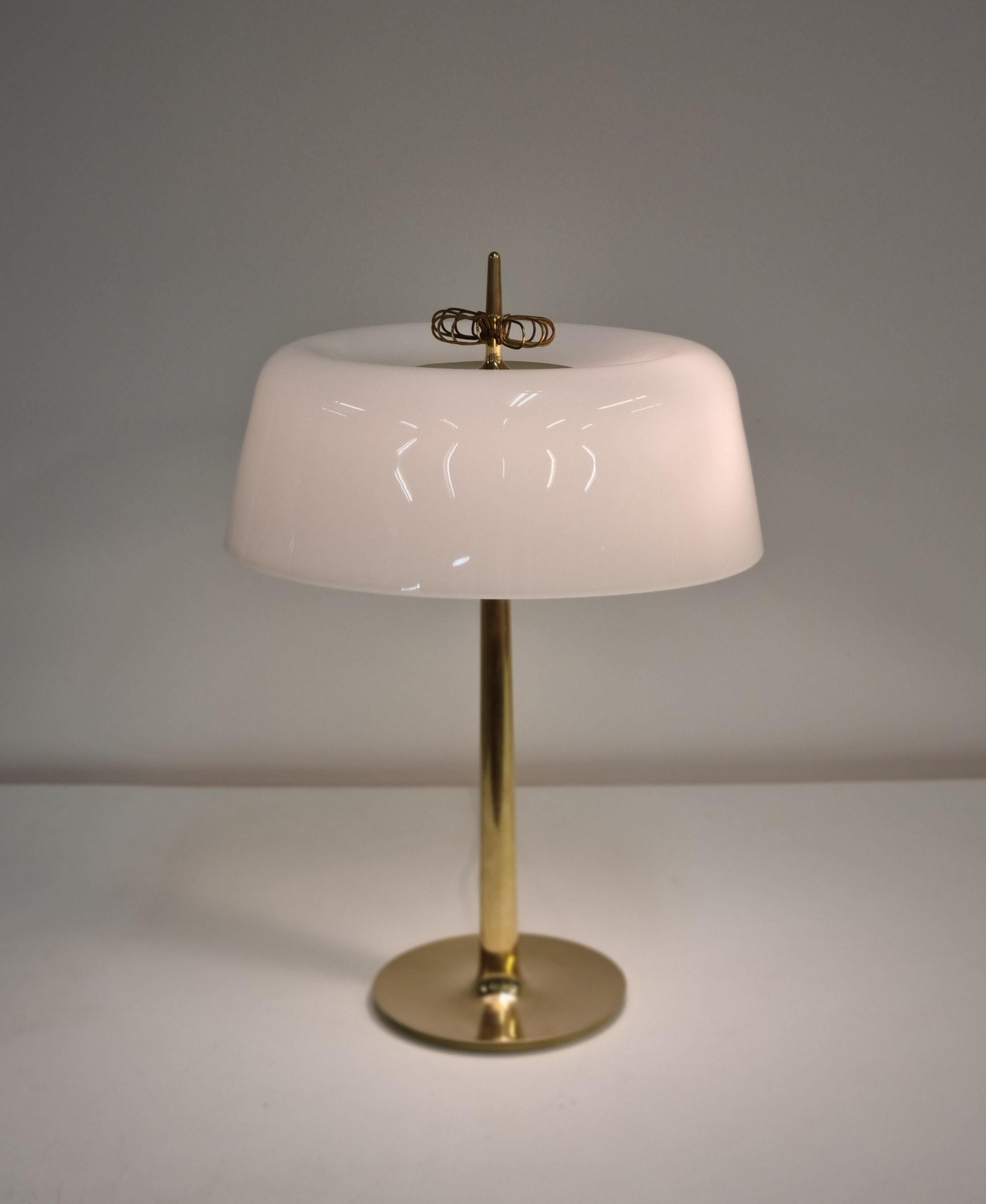 This is a really elegant, rare desk lamp model 9211 by Paavo Tynell (1890-1973)
from 1950s for Taito, Finland. It is in it's original condition. 
The lamp body is made with cast brass and has a sleek seamless shape covered with a white rounded opal