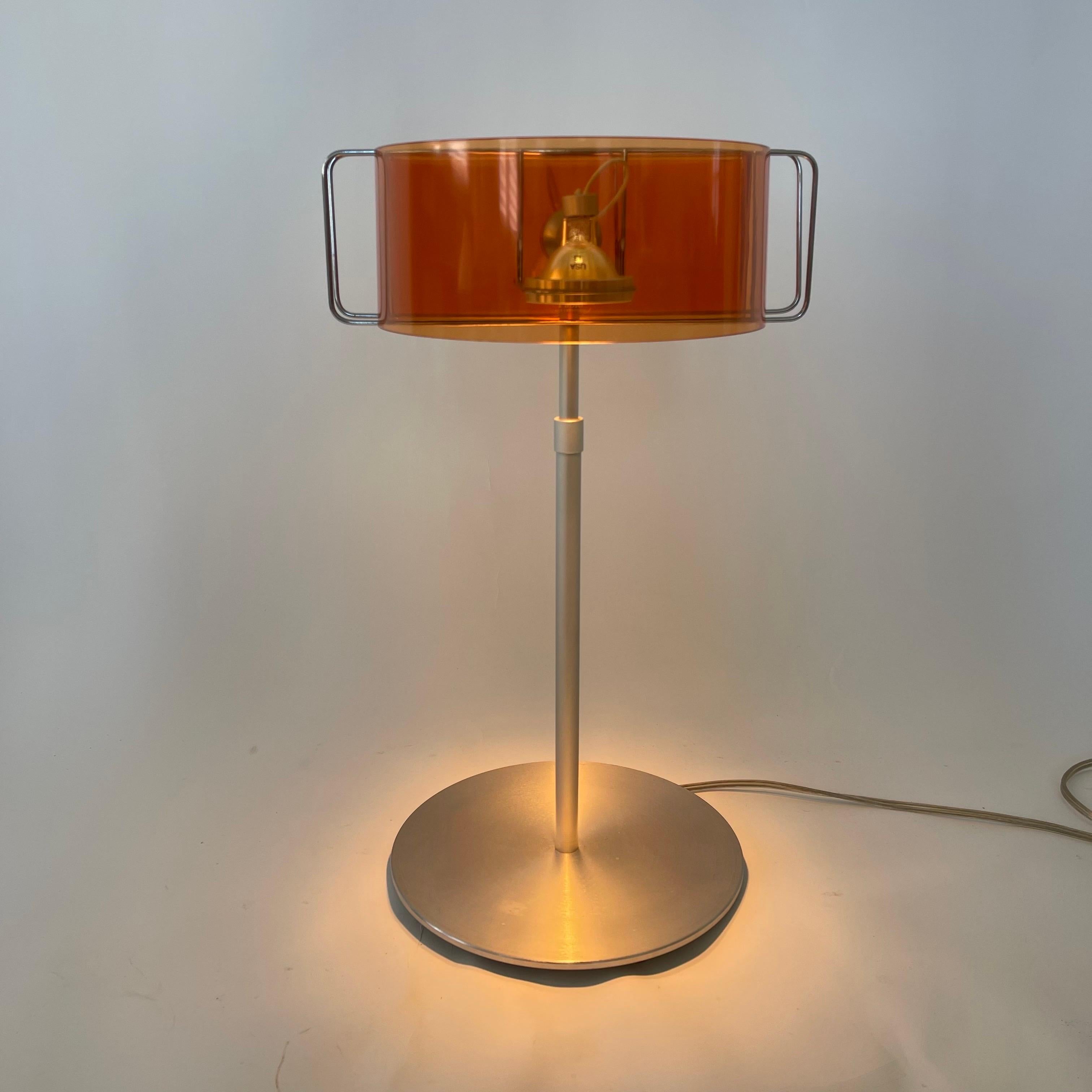 Fully adjustable Modern table or task lamp, rendered in a spun aluminum base and stem with two orange bent acrylic shade that revolves left and right as well as up and down individually allowing the user to adjust the two lights as needed.  Designed