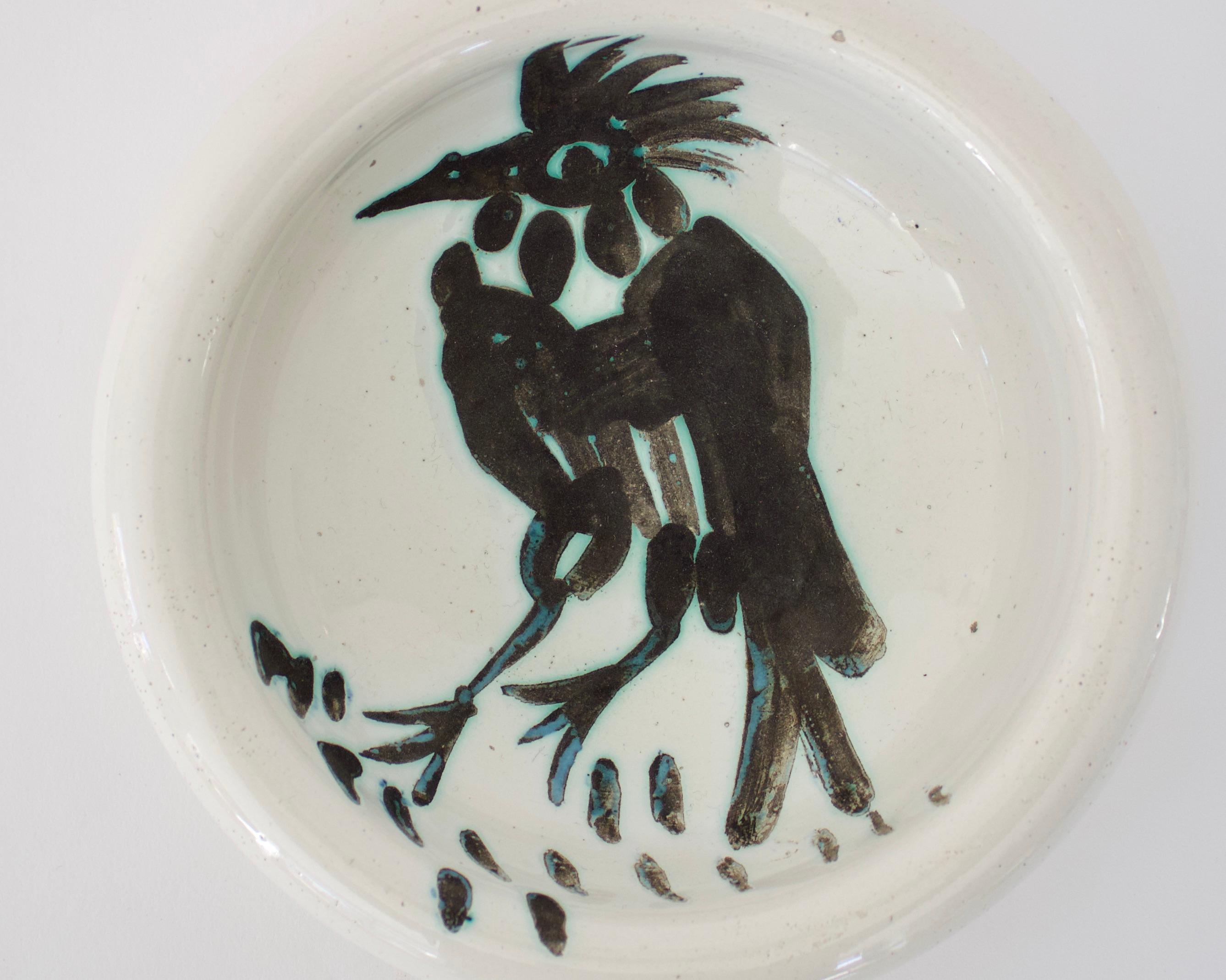 Pablo Picasso Oiseau dish bird with tuft and pointy beak, editions Picasso Madoura France, circa 1952. 15 hand painted brush strokes under the birds feet referring to food. 
Impressed with mark to underside Madoura Plein Feu edition Picasso and