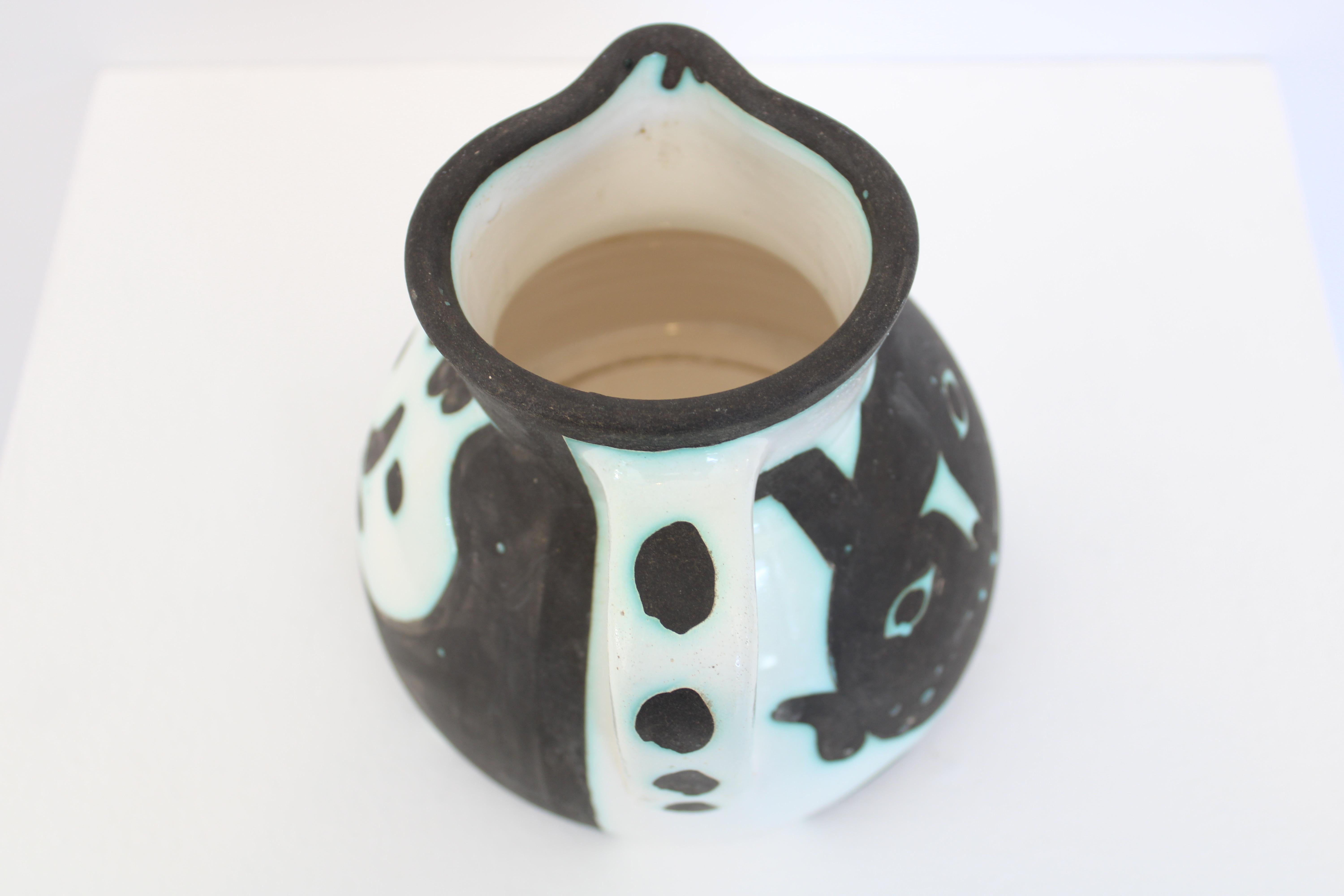 Madoura turned pitcher of white earthenware clay with decoration by Pablo Picasso black and white drawings. This work is stamped with the 'MADOURA PLEIN FEU' and 'EDITION PICASSO' pottery stamps on the underside. c1956
Excellent condition with no