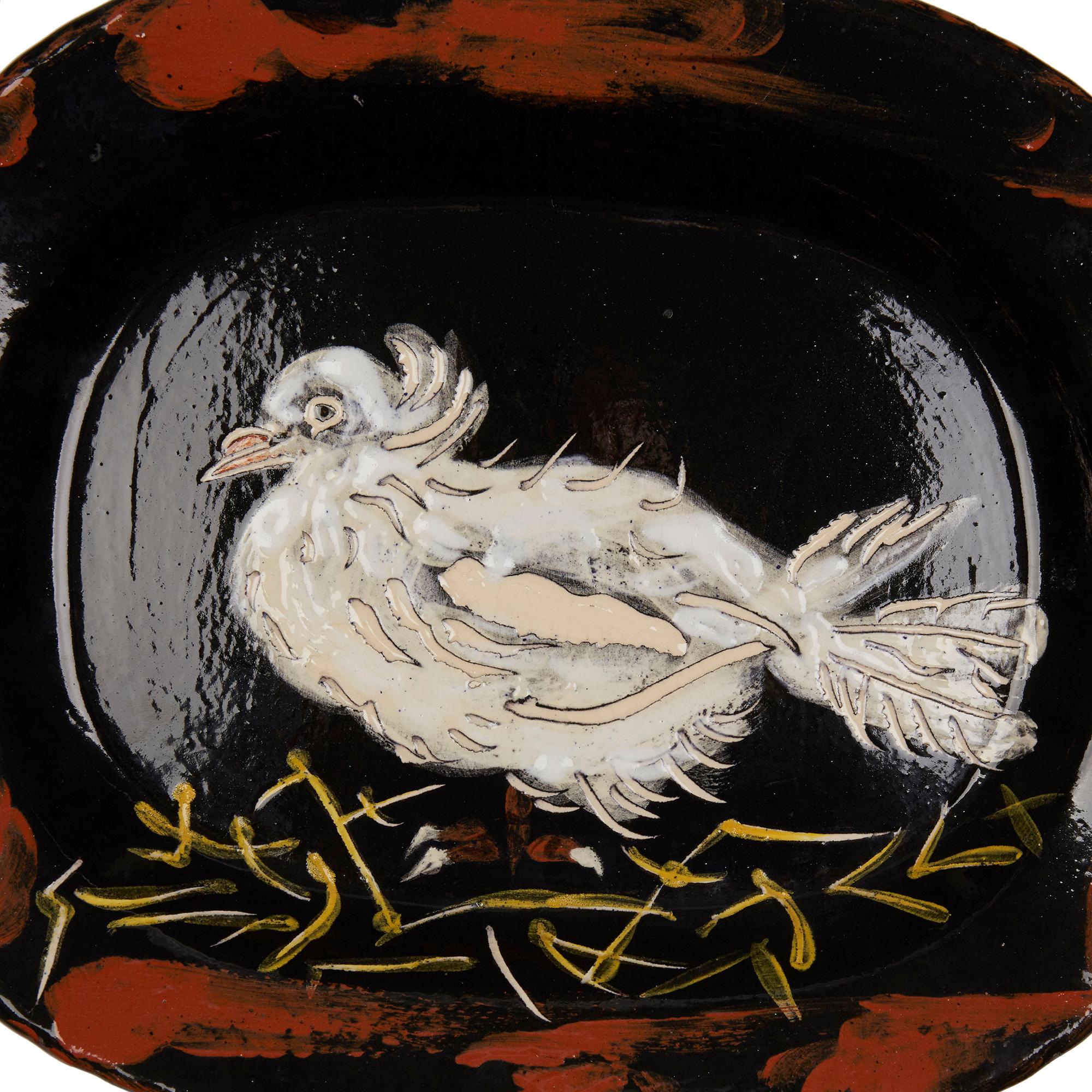 Colombe sur lit de Paille (dove on bed of straw) and incised 'Madoura Plein Feu/Edition Picasso'

This white rounded rectangular earthenware dish is decorated with a dove, of slightly disheveled appearance, on a straw bed in red, yellow and white