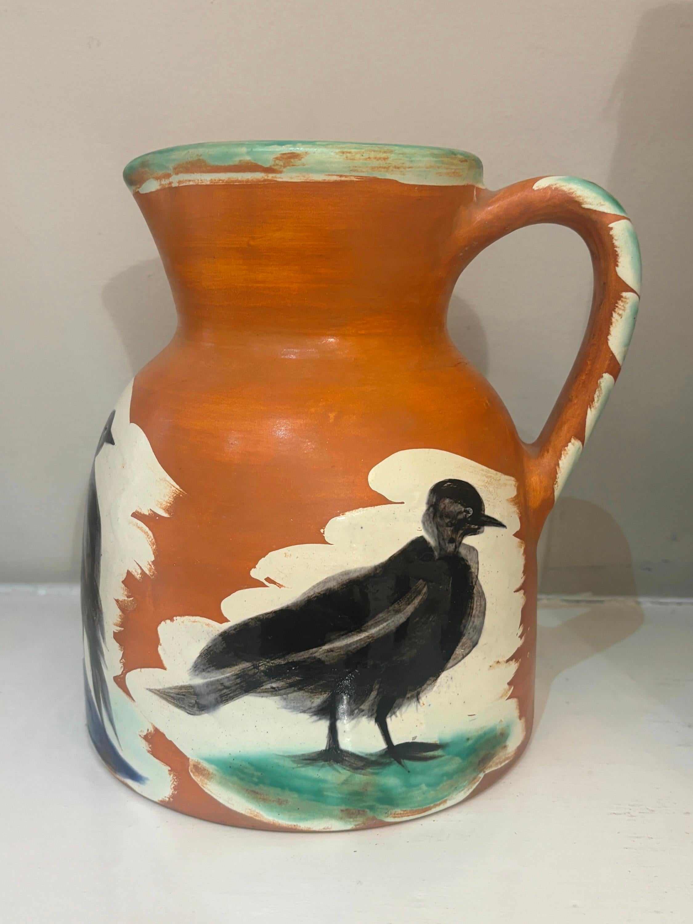 White earthenware pitcher painted in colours with brushed glaze, conceived in 1962. With the Madoura Plein Feu and Edition Picasso stamps on underide of base; incised Edition Picasso Madoura and numbered 116 of 200 copies. Dimensions: 22 x 18 x 15