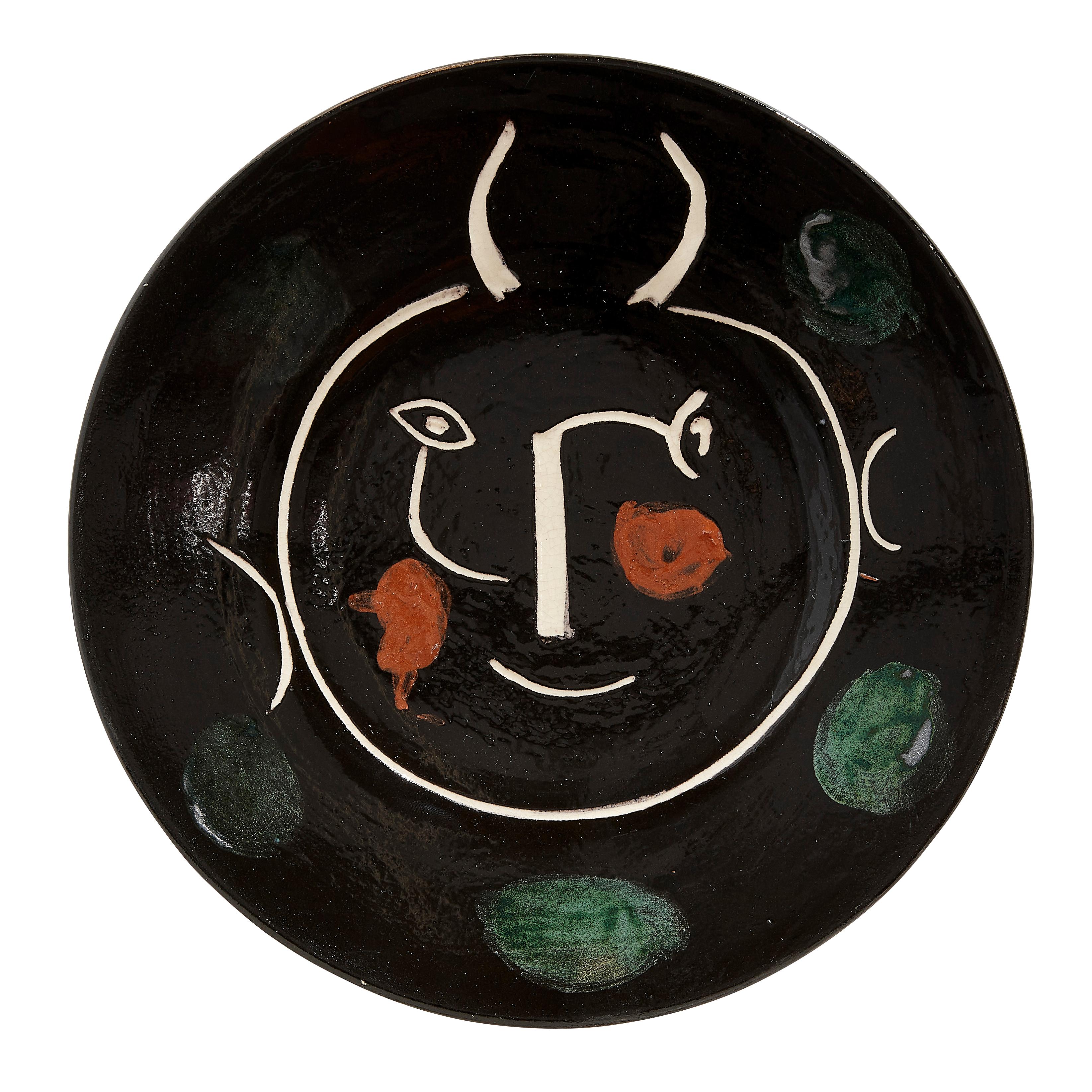 PABLO PICASSO (1881-1973) 
Service visage noir (A. R. 40)

Terre de faïence plate, painted in colors and glazed, 1948, from the edition of 100, inscribed 'E', 'd'apres Picasso' and 'Madoura', with the Madoura stamp.