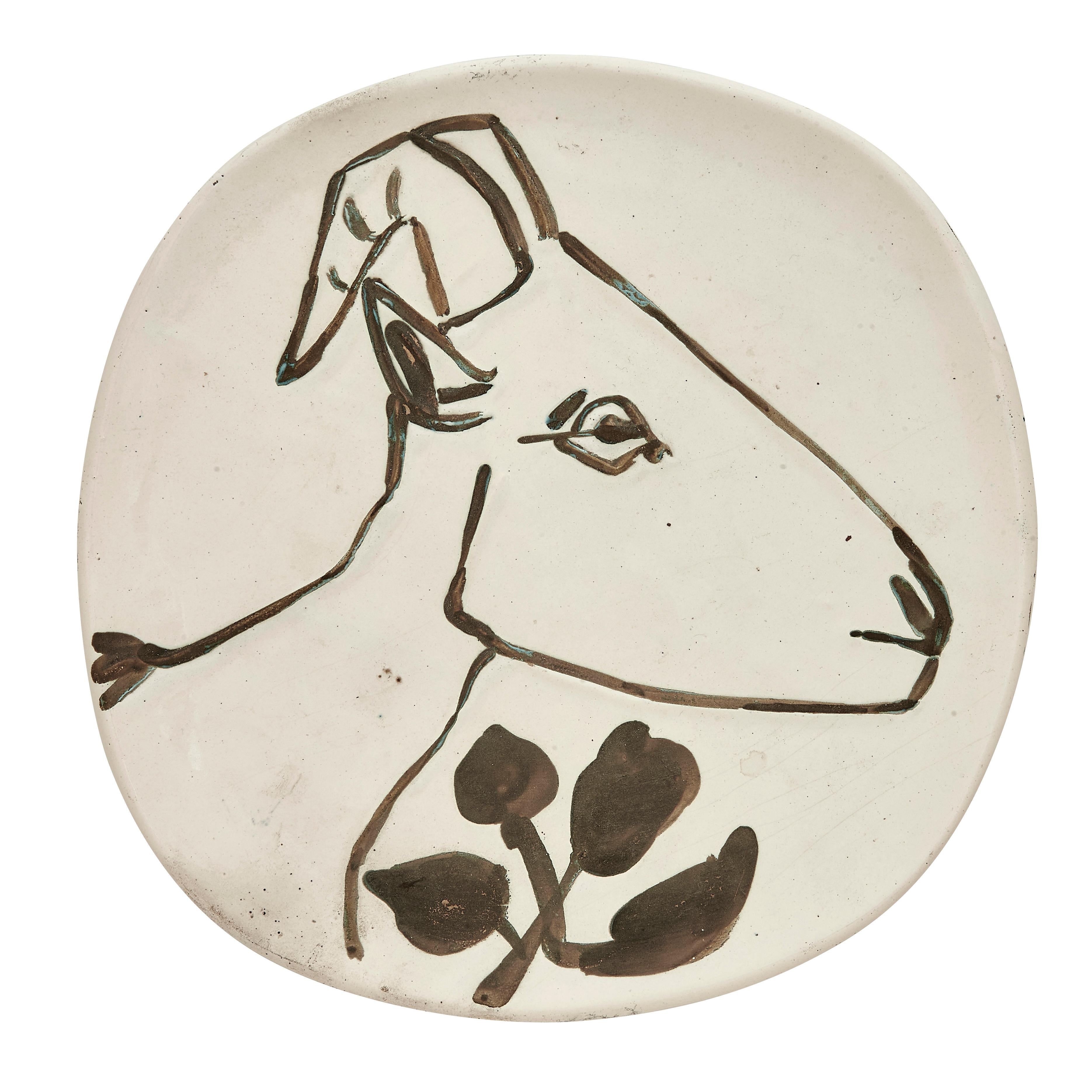 PABLO PICASSO (1881-1973) 
Tête de chèvre de profil (A. R. 106)

Terre de faïence plate, 1950, from the edition of 50, partially glazed and painted, with the Empreinte Originale de Picasso and Madoura stamps.