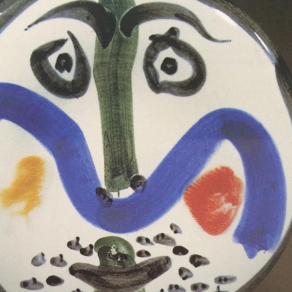 This piece is an A.R. round plate by Pablo Picasso, created in 1963. It is made with white earthenware clay plate, decoration in engobes and enamel under glaze in black, red, green, blue and yellow . It is numbered from the edition of 150 copies on