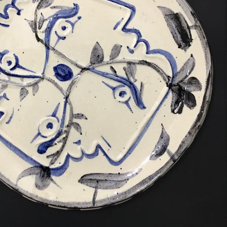 This piece is a unique variation round plate by Pablo Picasso, created in 1949. It is made with white earthenware clay plate, decoration in engobes and enamel under glaze in white and blue.  The diameter of this piece is 10.6 inches. This plate is