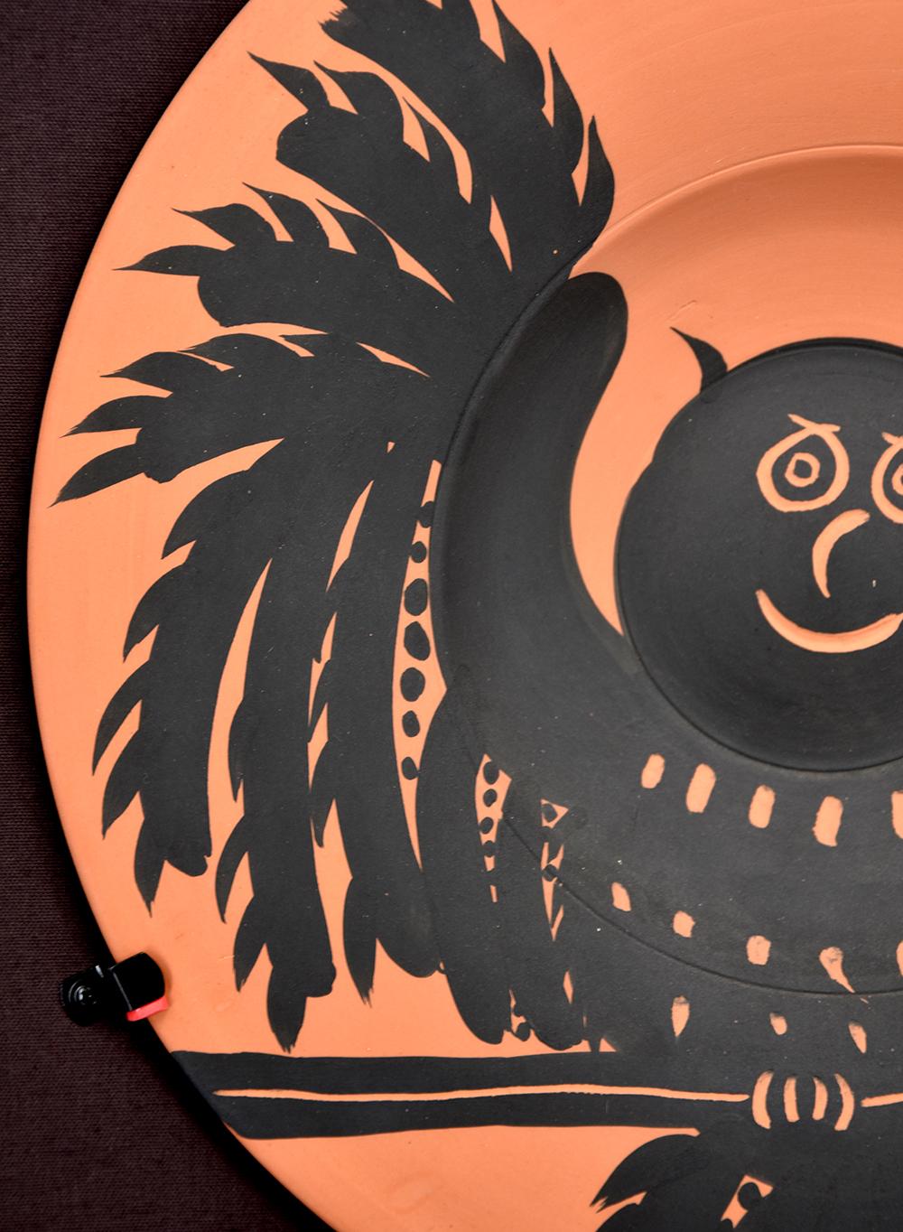 Créé en 1975, ce plat rond tourné madoura en terre cuite rouge, décor à l'engobe en noir et gravure au couteau est issu de l'édition de 200 et  estampillée au dos des cachets de la poterie 
