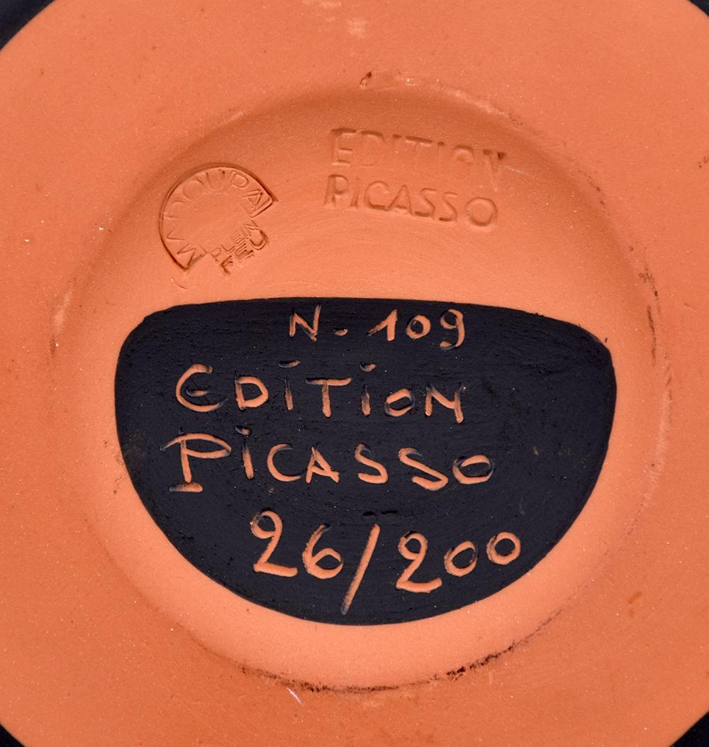 Created in 1975, this madoura turned round dish of red earthenware clay, engobe decoration in black and knife engraving is from the edition of 200 and  stamped with the 'MADOURA PLEIN FEU' and 'EDITION PICASSO' pottery stamps on the back.

Pablo