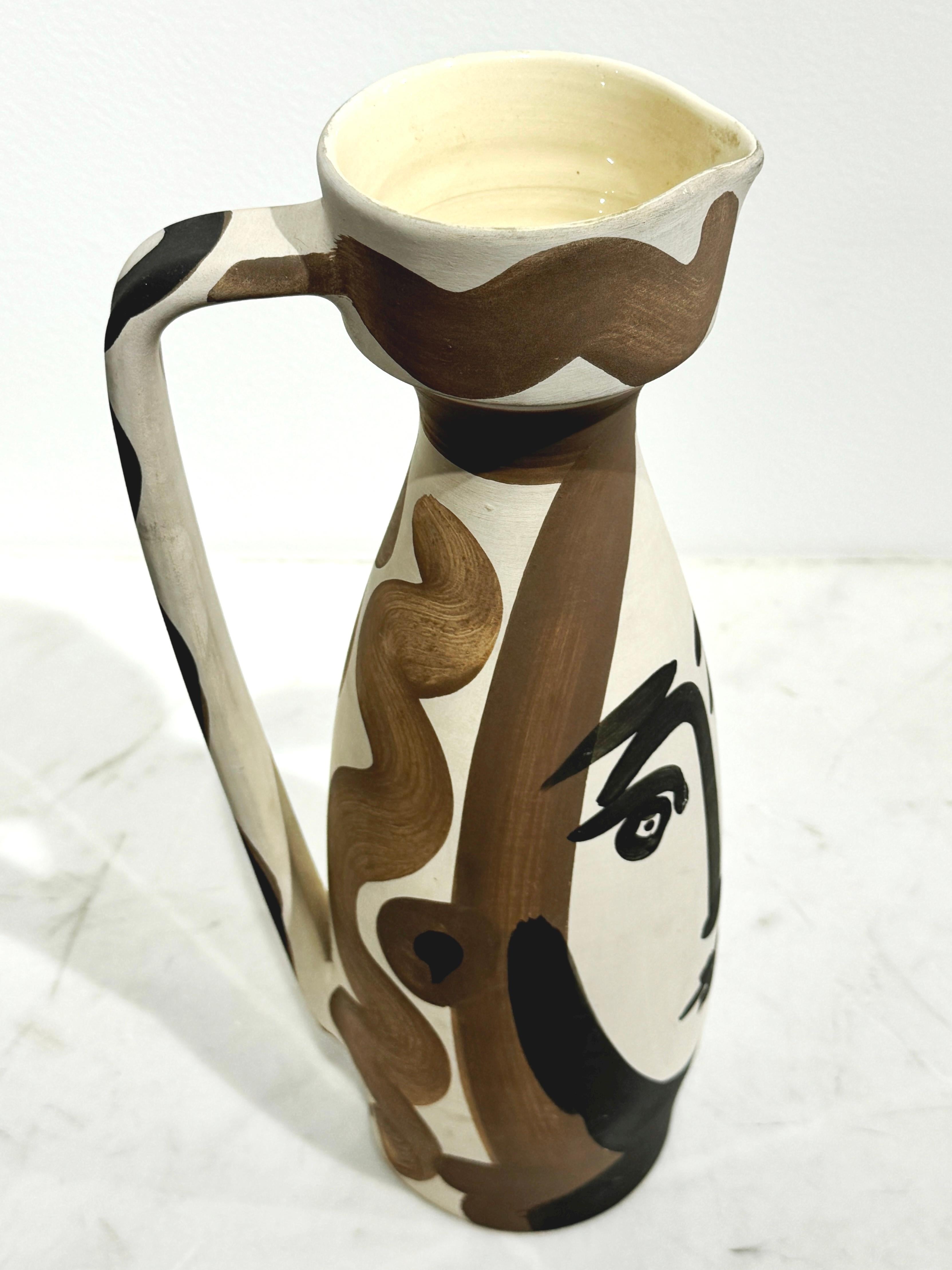 Pablo Picasso 1881 - 1973 

Brocca con la faccia girata

1955

Brocca trasformata, A.R. Argilla di terracotta bianca, decorazioni in ingobbio, smalto interno rosso e nero. 

12,4H x 4,13 pollici
31,5H x 10,50W cm 

Edizione  500 copie