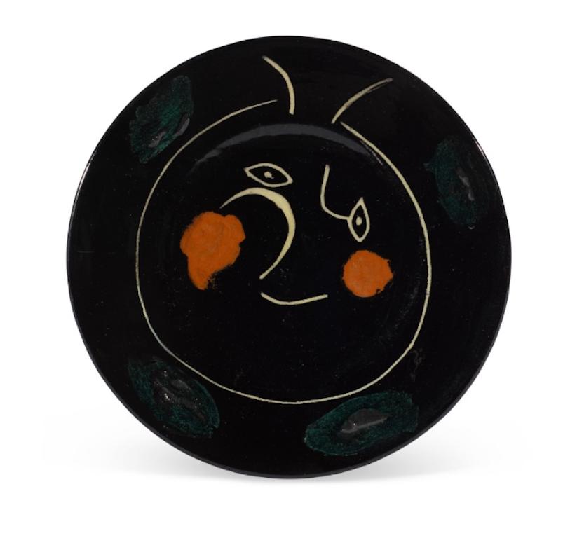 Picasso's Madoura Ceramic Plate - Service Visage Noir, Ramié 47 is one in an edition of 100 numbered copies produced inscribed "L" on the back. The plate is part of a set of 10 similar ceramic pieces, made of white earthenware clay, partially