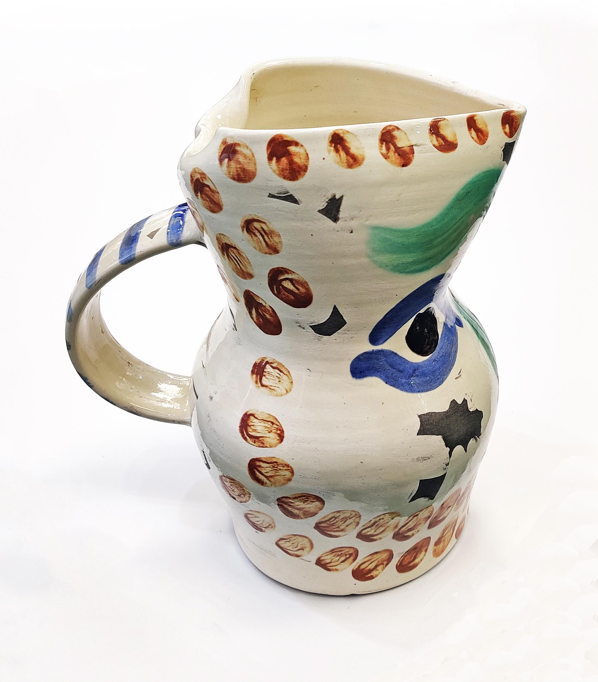 White earthenware pitcher painted in colors and partially glazed. Alain Ramié 610. Georges Ramié 759. Incised `Edition Picasso', `R 139', `Madoura', numbered 242/350 and with the Edition Picasso and Madoura Plein Feu pottery stamps on the