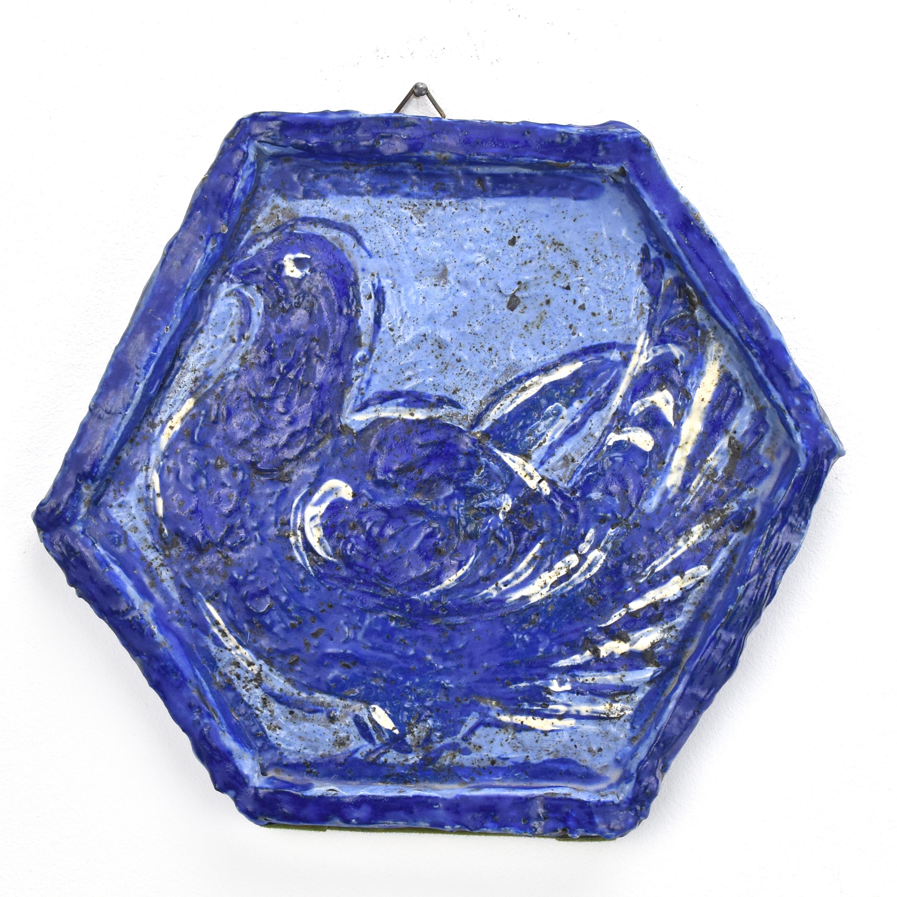 A beautiful hand painted and thickly glazed decorative wall tile by an unknown artist, influenced by the works of Pablo Picasso.

The wall plaque is decorated with a dove in different shades of blue with white accents.

Funny and whimsical, you can