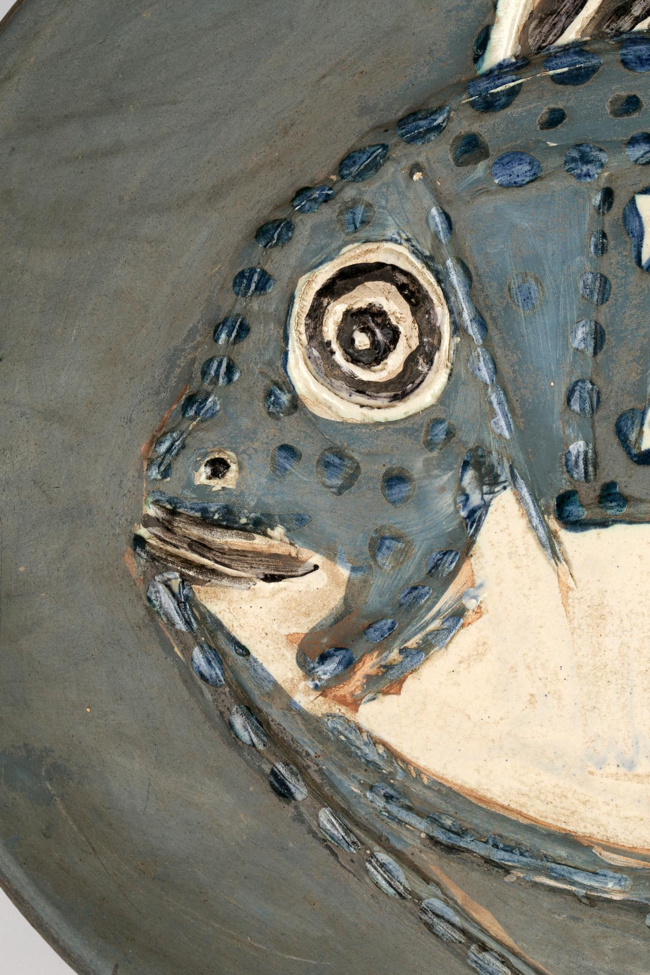 A unique variant Plat Poisson (see A.R. 166-171) terre de faience platter portraying a fish by Pablo Picasso and dated 6th June 1952. The oval shaped platter is potted in white earthenware clay and decorated in raised engobe colors set within a grey