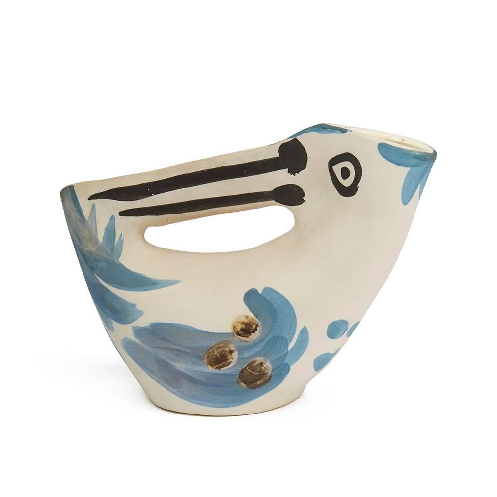 Terre de faïence pitcher, 1953, numbered 73/200 and incised 'Edition Picasso' & 'Madoura'.

The pitcher's design is based on an avian form. This piece is partially glazed and is hand painted with blue, black and brown decoration. 

This piece is