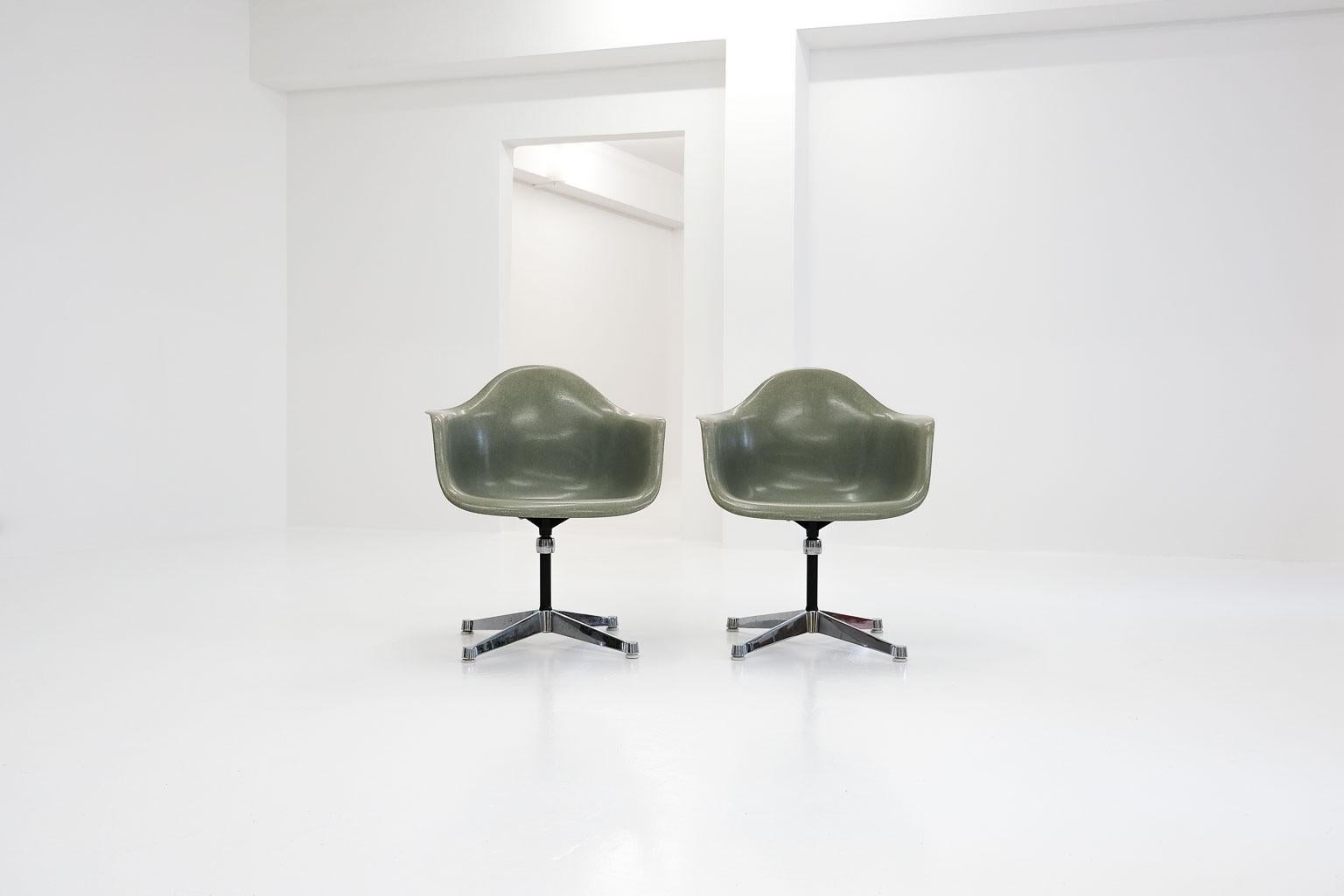 a couple of eames armchairs with contract base. the perfectly matching fiberglass shells in the color called seafoam have become rar, and are in very good vintage condition (no cracks etc.). produced by herman miller with the comfortable flat arm