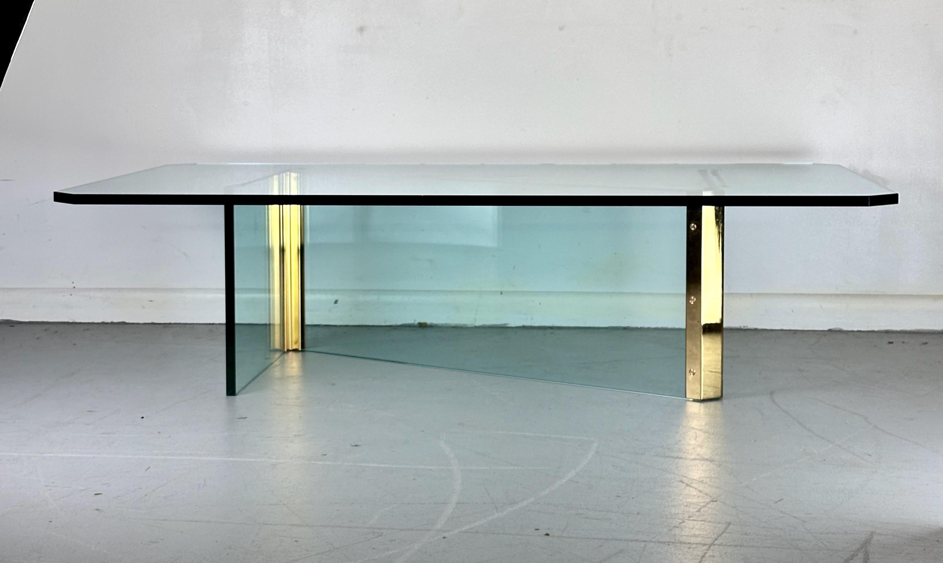 Dieser auffällige Mid-Century Modern Couchtisch zeichnet sich durch eine einzigartige Mischung aus Messing und Glas in einem Z-Design mit einer dicken, abgeschrägten Glasplatte aus. Dieser Tisch im Stil der Leon Rosen for Pace Collection'S ist eine