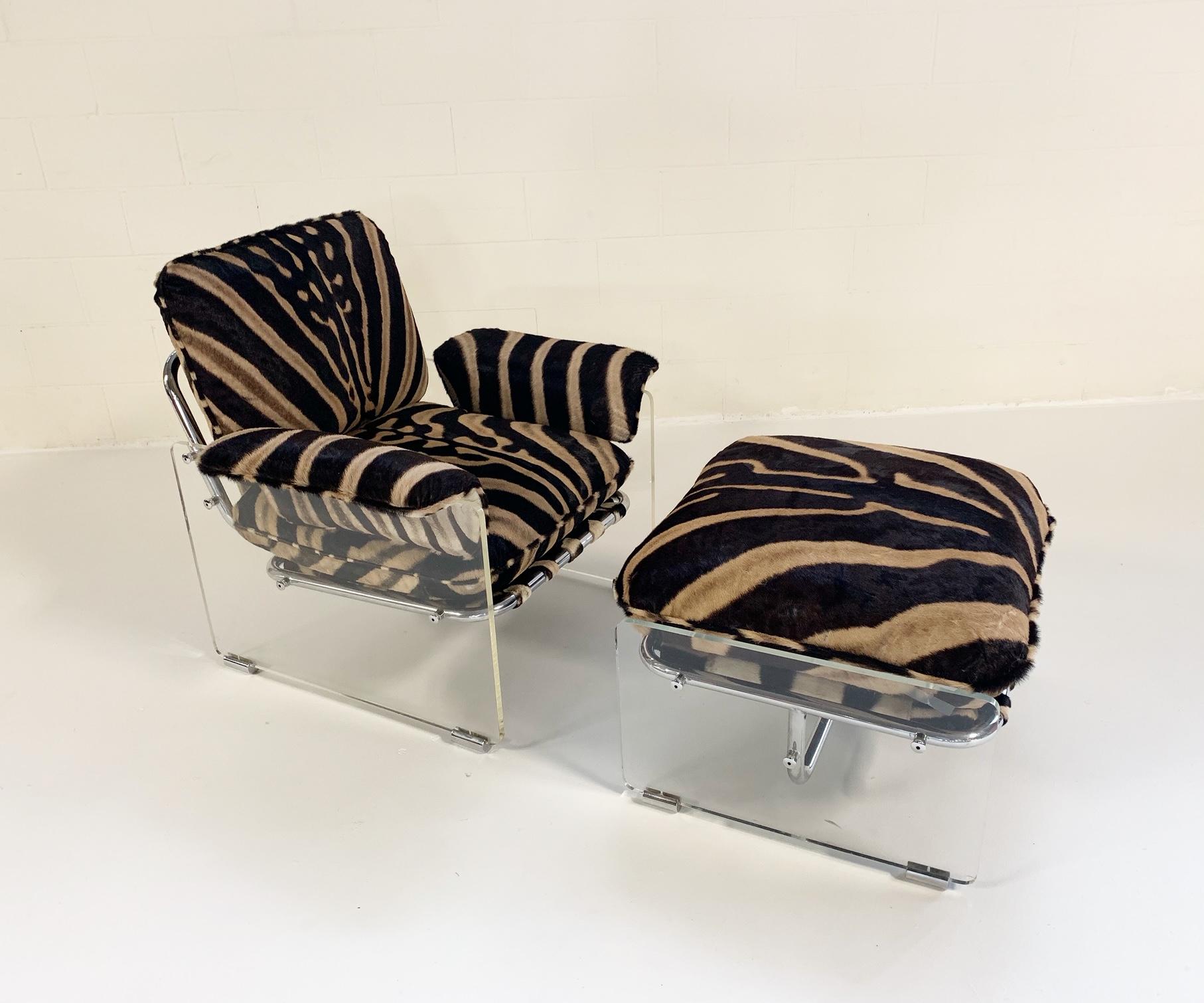 This amazing one of a kind 1970s Pace Collection lounge chair and ottoman features thick Lucite panels with chrome details. Zebra hide straps wrap the tubular chrome frame to support the cushions. The loose cushions have been masterfully upholstered