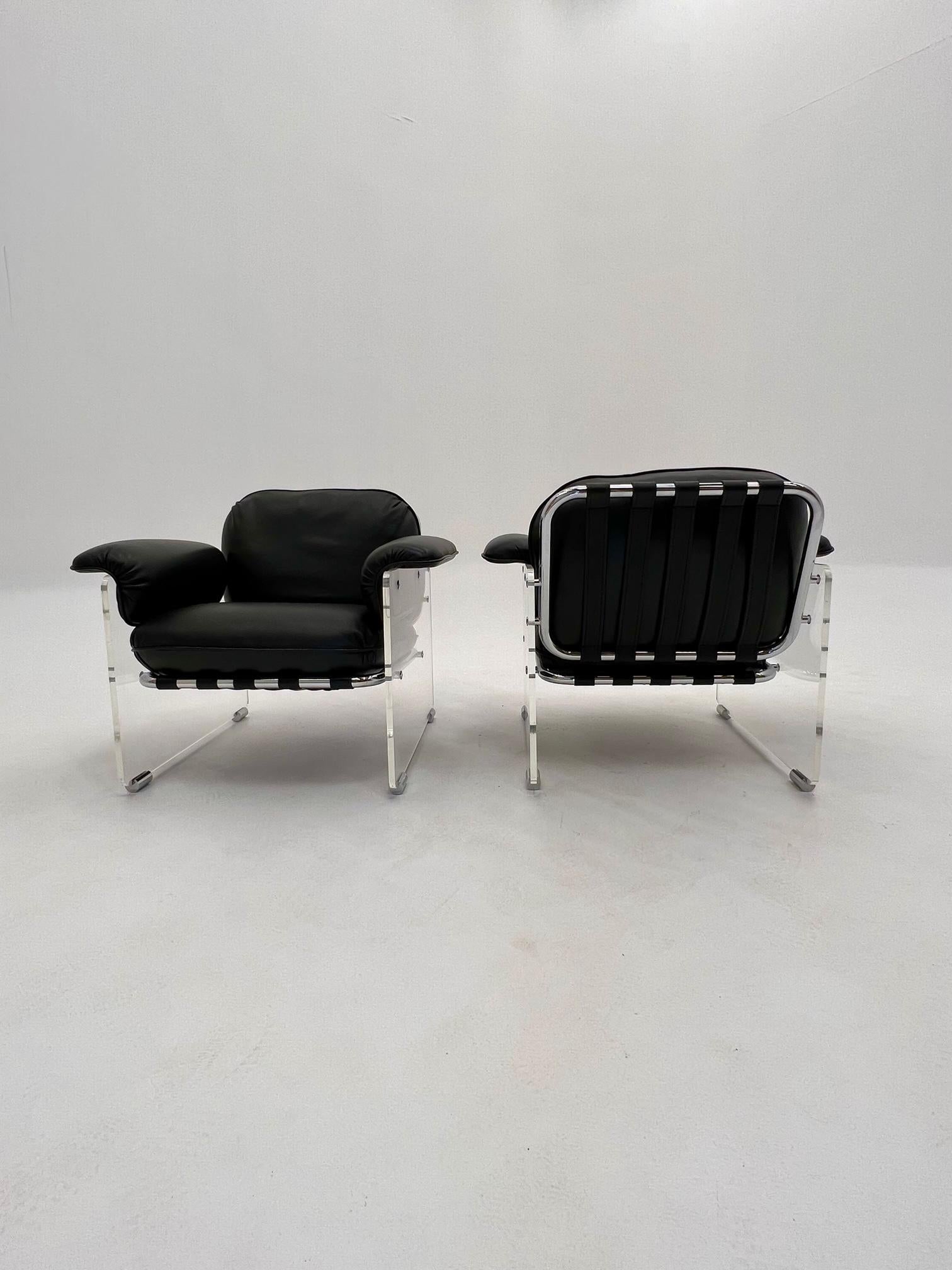 A pair of vintage Argenta Lucite chairs from Pace. These two,  are completely reupholstered and refinished with smooth black calfskin leather, which includes the supportive under-straps. They are later Mid-Century modern. The chrome is in very good