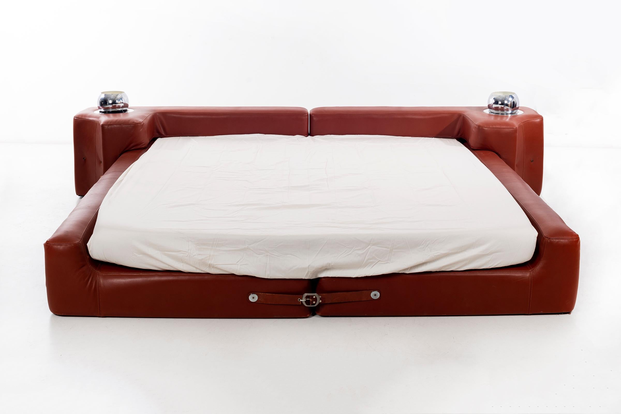 Pace collection leather bed by Guido Faleschini for Mariani. Features two built in adjustable chrome lights on headboard surface. Leather strap detailing at foot of bed.