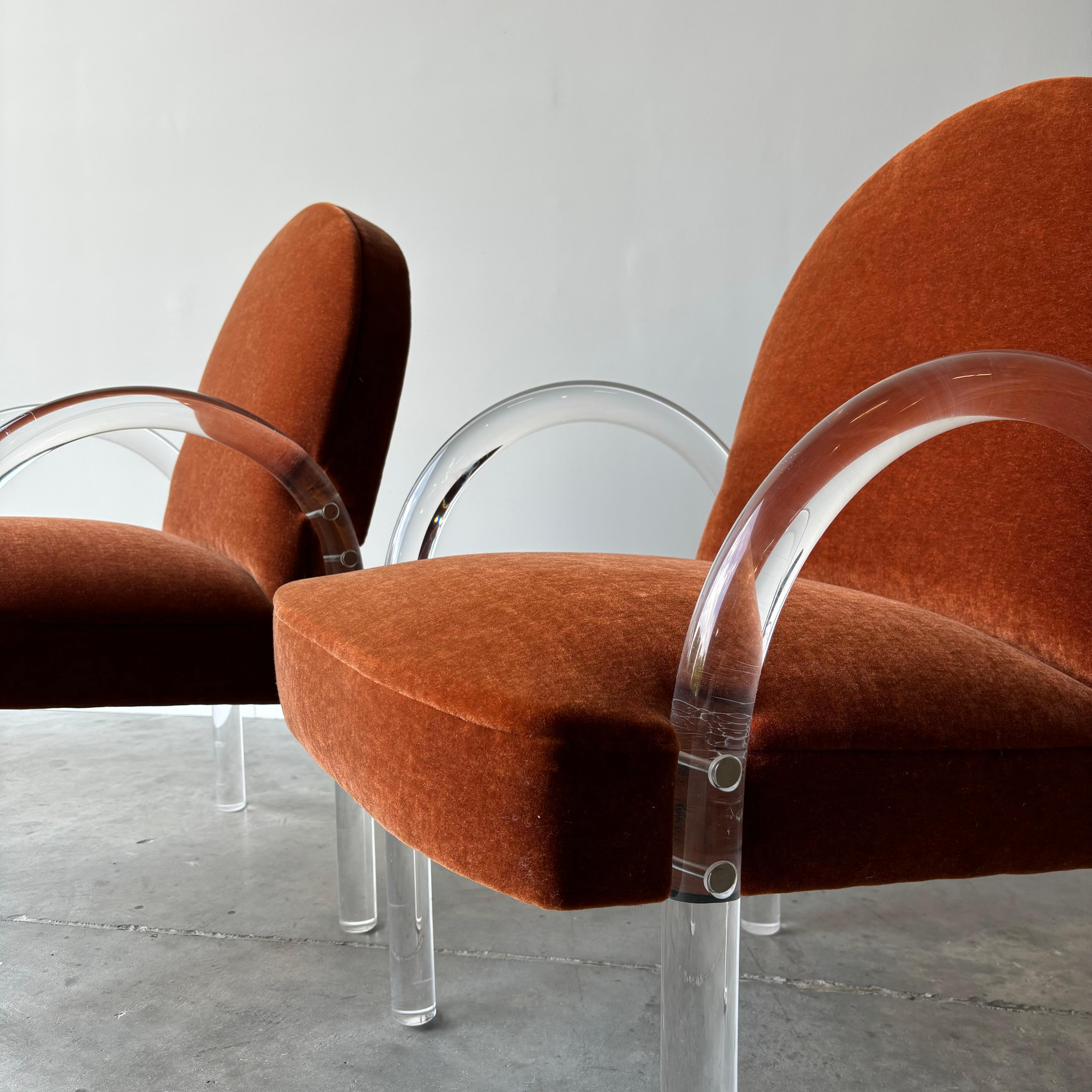 A pair of chairs by Pace. Thick Lucite arms and mohair upholstered seats. The design is clean and to the point. 
The chairs are well proportioned and comfortable, and work as a great pair of occasional lounge chairs.

Lucite shows hairline fissures