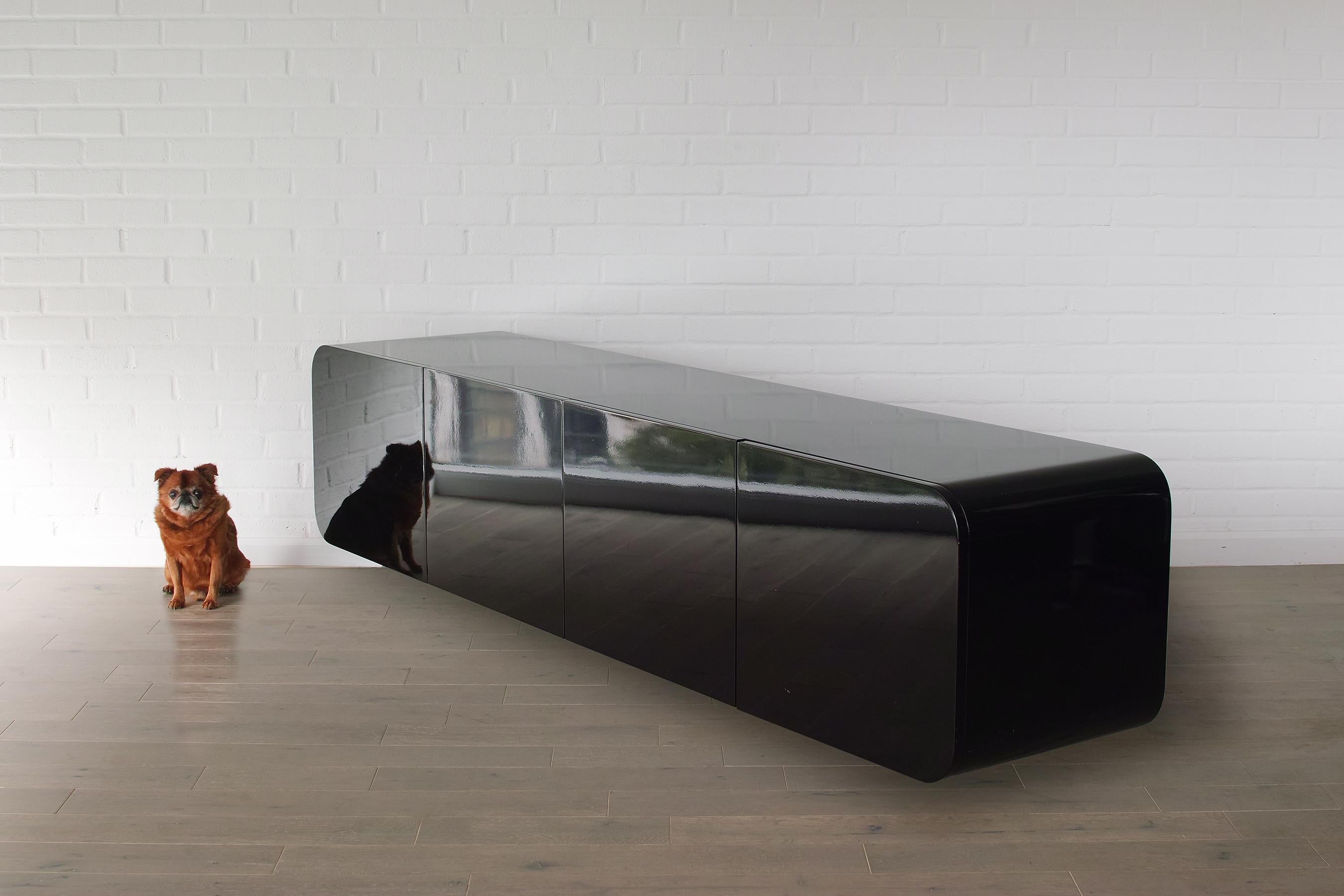 For your consideration is this all-original, black lacquer, wall mounted credenza by Janet Schweitzer for Pace Collection. The credenza features its lovely, original high-gloss black finish. Four doors conceal three adjustable shelves and two