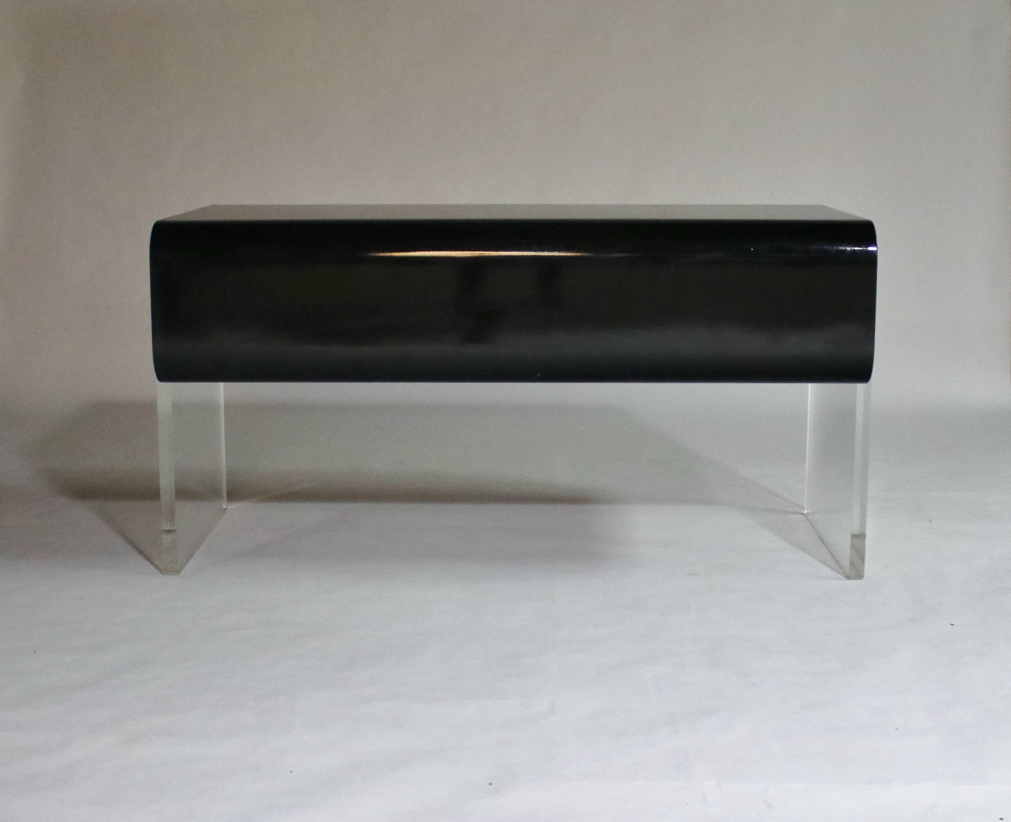 Mid-Century Modern black lacquered wood desk with four drawers floating on thick Lucite legs attributed to Pace. Unique design features two long, shallow pull-out bottom drawers, two deep top drawers and middle pencil drawer. 

Provenance: From