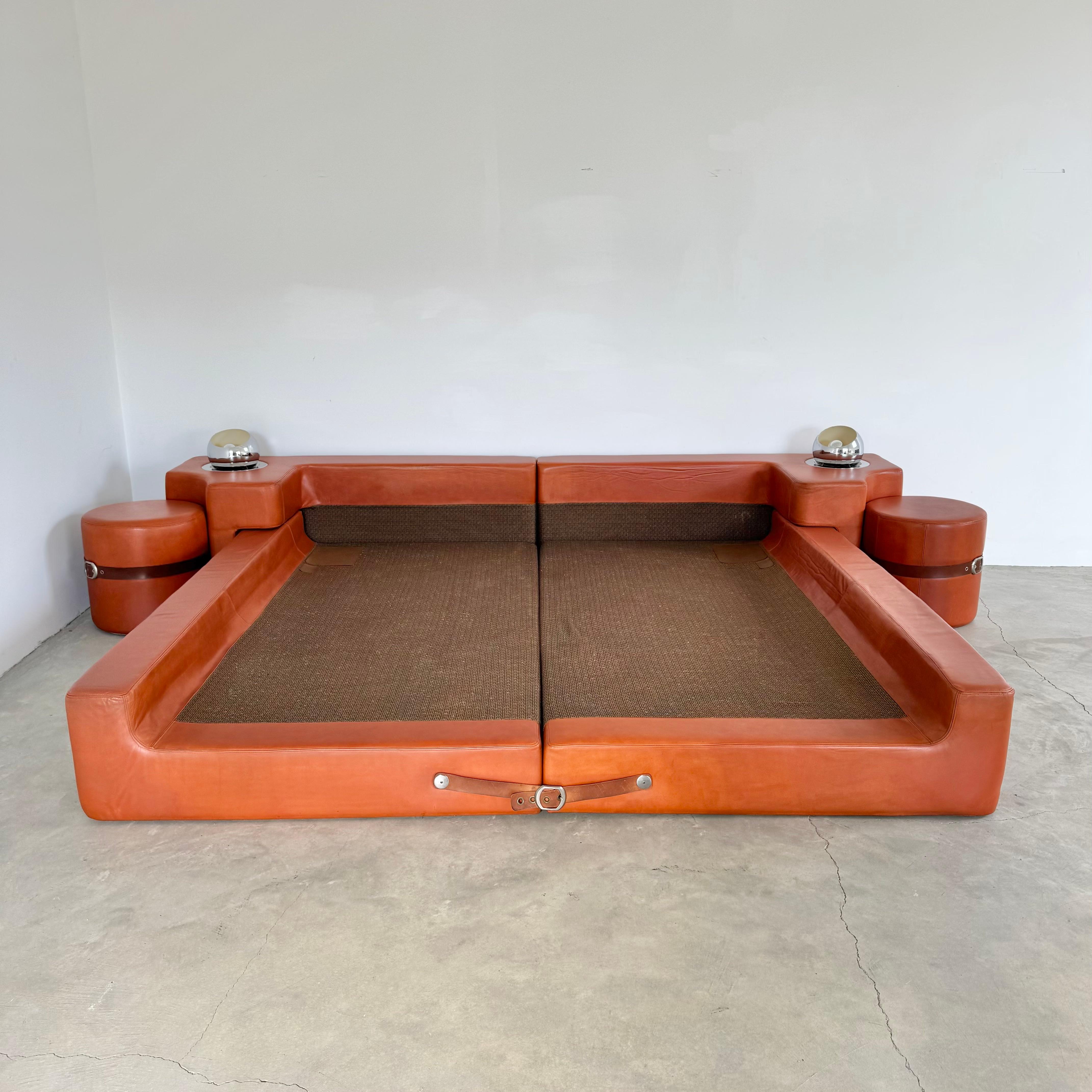 Cama de piel tamaño king de Guido Faleschini para Mariani/Pace. Fabricado en la Italia de los años setenta. Incluye dos pufs integrados. Todo el conjunto está meticulosamente envuelto en auténtica piel. Detalles de correas de cuero a los pies de la