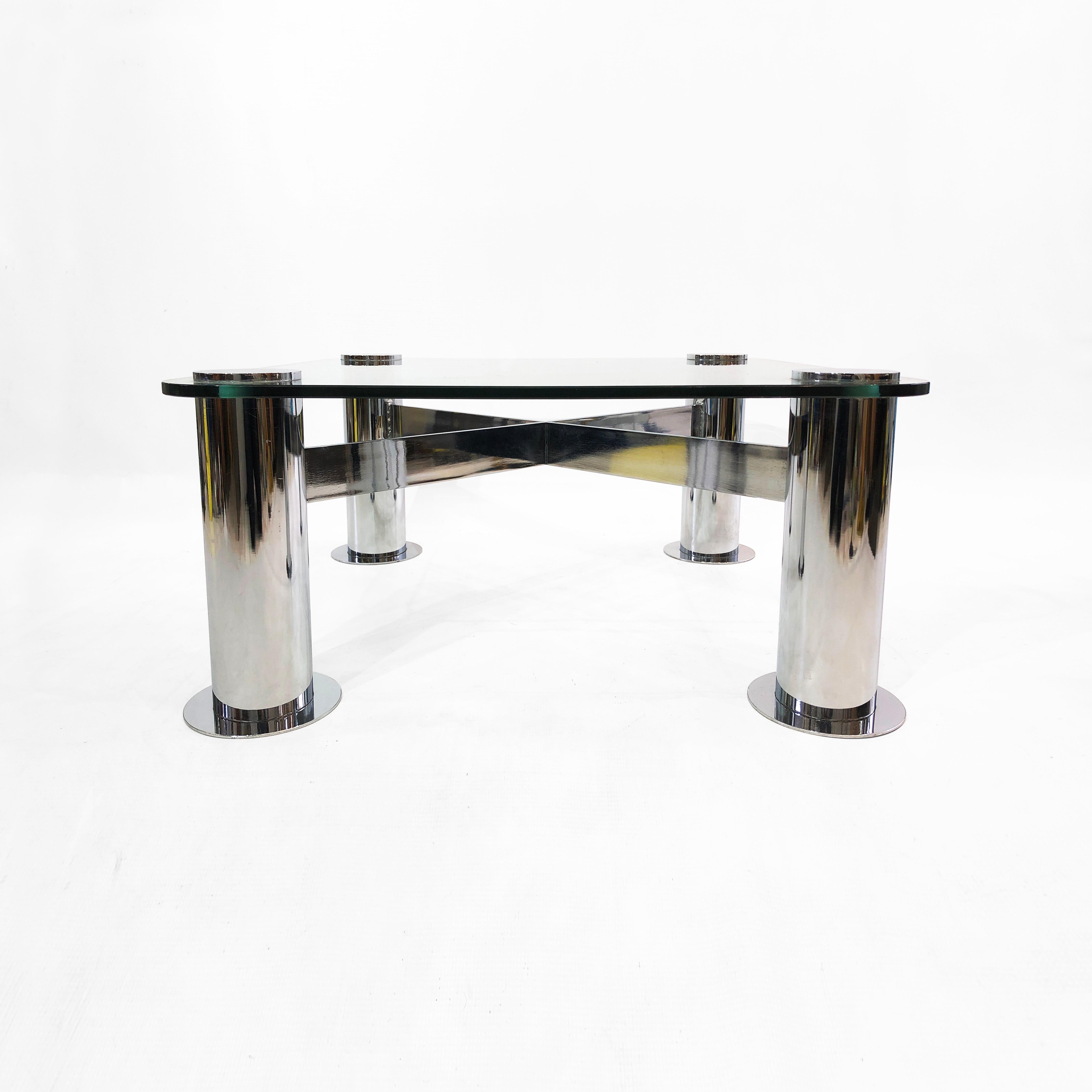 A stunning post-modern chrome and glass coffee table, by Leon Rosen for Pace Collection. The piece, takes its cues from the structural expressionism architectural movement reminiscent of bold buildings of the era. It consists of an interlocking