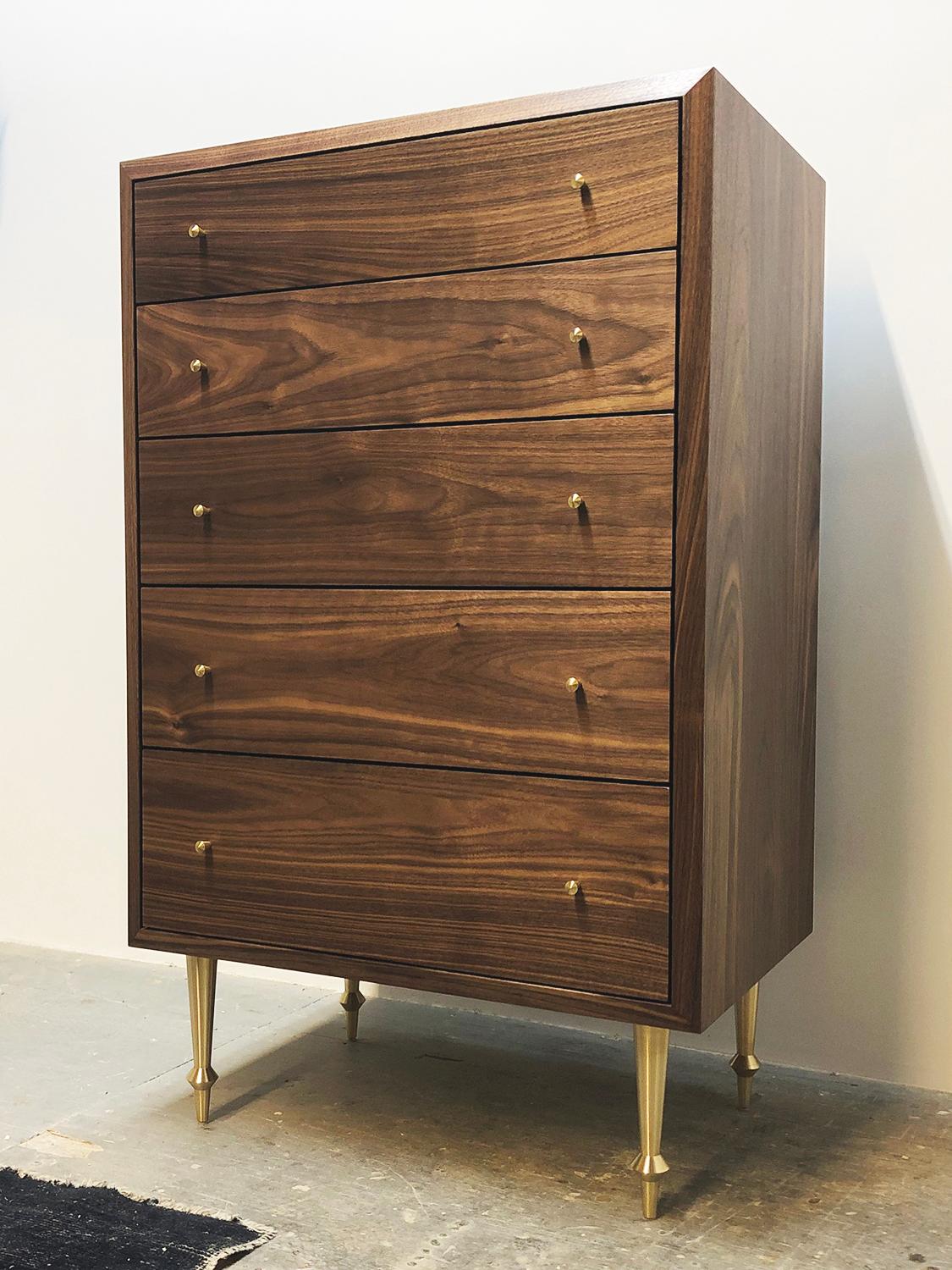 An elegantly simple dresser with graduated drawers, beautiful wood grain and lovely brass hardware.
Solid walnut with turned brass legs and drawer pulls.
Dimensions: 42” H x 26” W x 18” D.
 