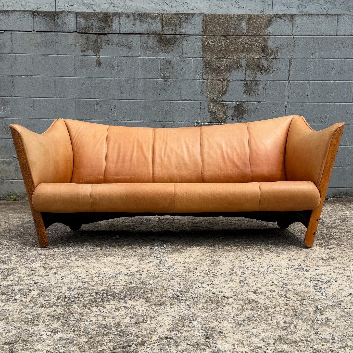Precioso sofá de piel plena flor Pacific Green con revestimiento de madera de coco en los laterales y el respaldo, forrado de piel. No hay cojines extraíbles. En excelente estado vintage, con pequeños signos de desgaste propios de la edad. Dos