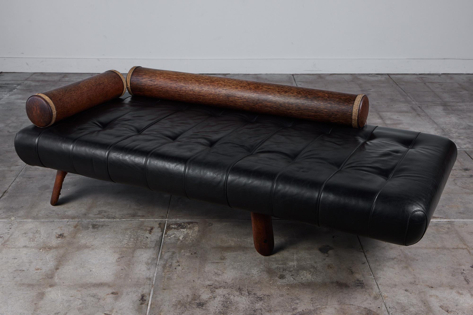 Chaise Lounge by Australian company Pacific Green Furniture. The handcrafted chaise features a rich black leather tufted seat on four splayed Palmwood legs. Two Palmwood bolsters finished in a rope detail rest on the seat of the chaise.

Pacific