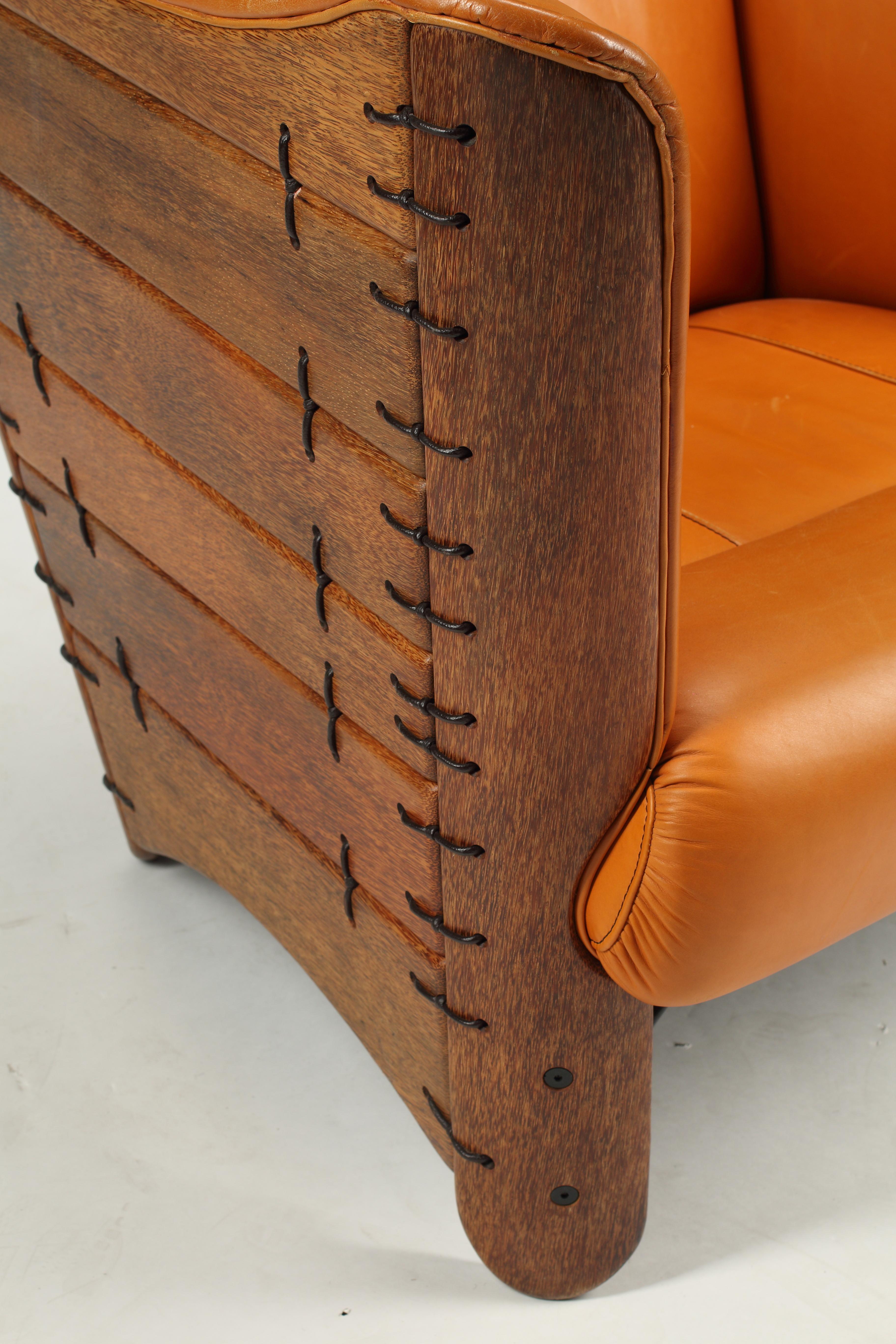 Vintage Pacific Green arm chair in cognac leather flanked by coconut wood panels. An exceptional vintage rendition of the Cayenne collection manufactured approximately twenty five years ago. Carefully, crafted by hand with full grain leather and