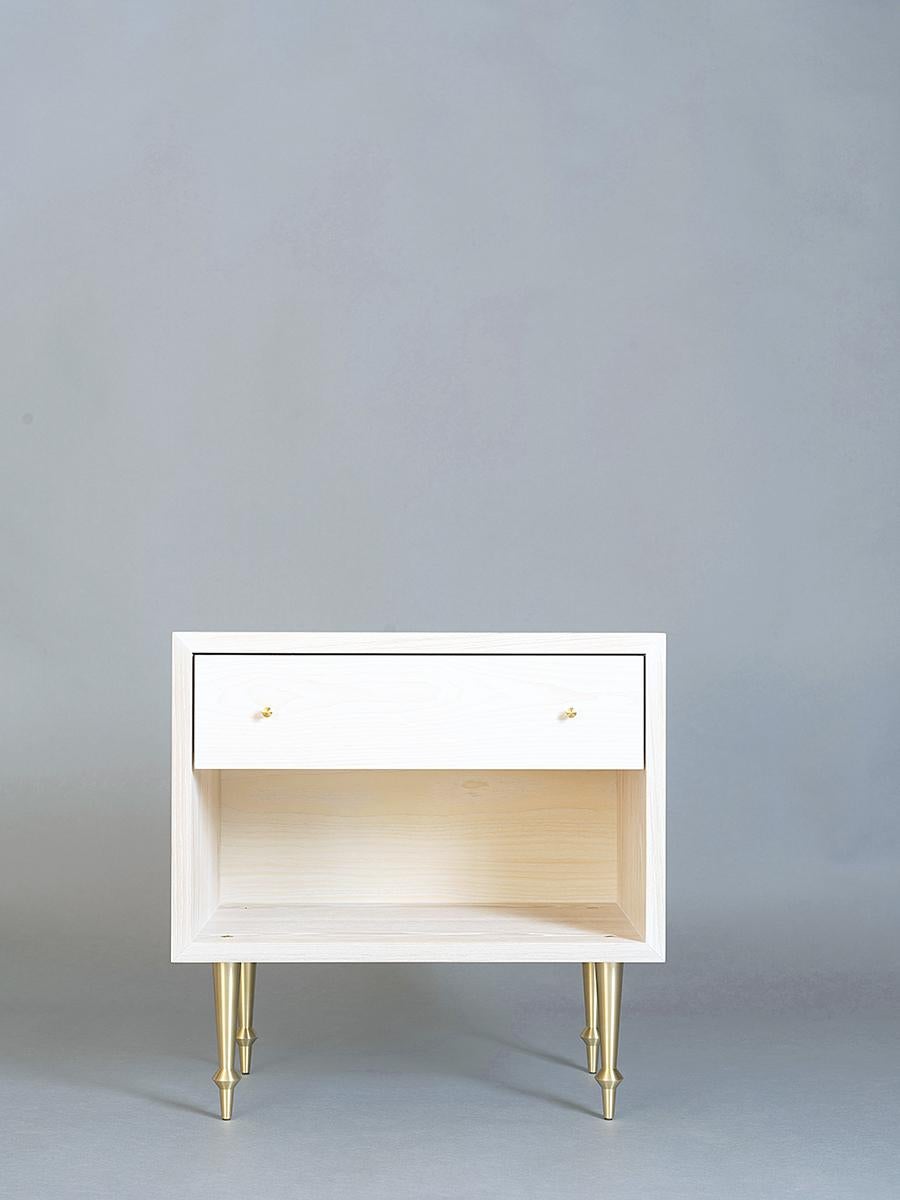 As shown:
Solid ash with brass legs and drawer pulls.
Bleached finish.
Dimensions: 24” W x 16 1/2” D x 24” H.
Custom sizing available.
Offered in a variety of hardwoods and finishes.