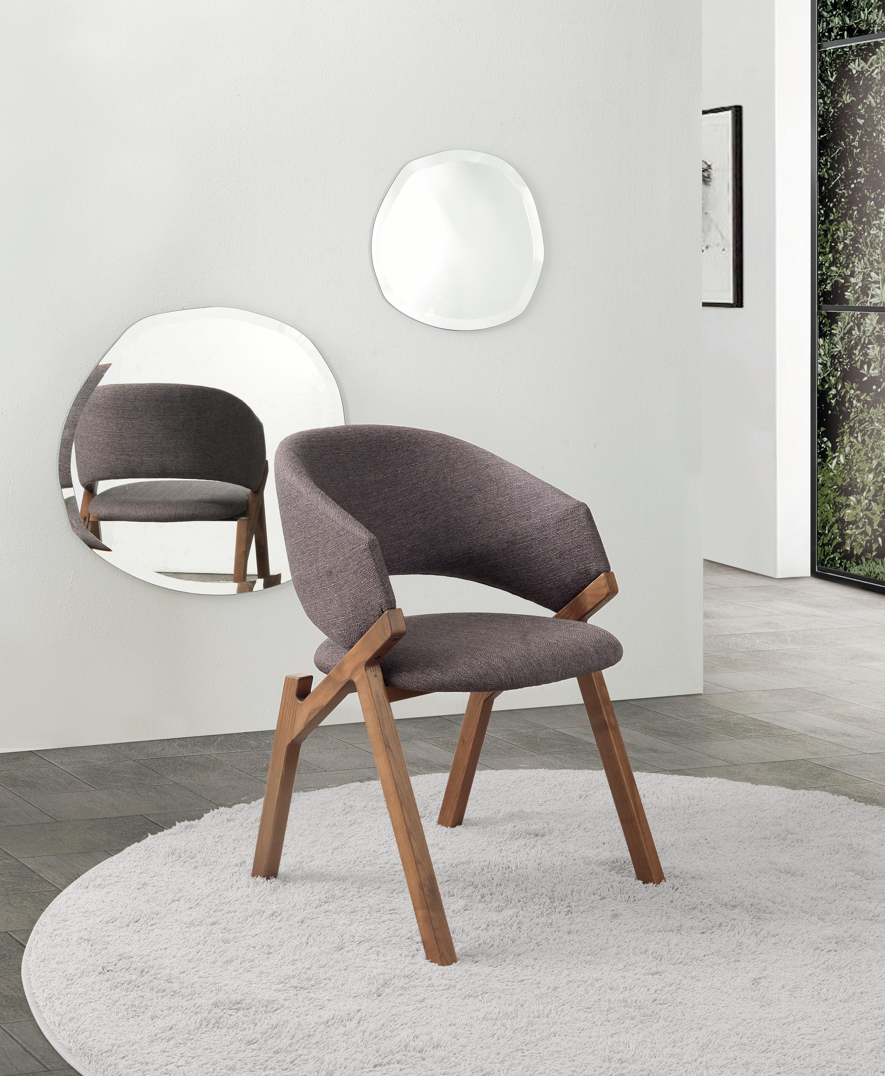 Chair with structure in solid ash. Seat and curved backrest covered in leather, eco-leather or fabric of the collection. Available finishings: WG wengé, NC ash stained walnut, TB ash stained tobacco, TN ash stained black, open pore matte lacquered