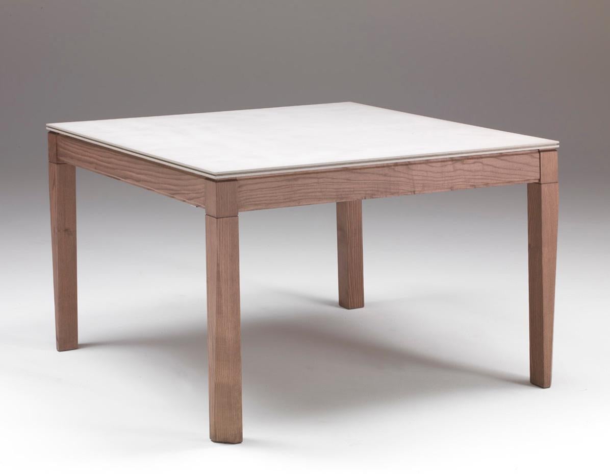 Dining table, extendable both in width and length, with extensions housed inside. Structure in solid ash. Ash. 5483: available also with Cimento (concrete C02 sand, C03 dove) top. Inner extensions veneered. Aluminium opening mechanism. Patented and