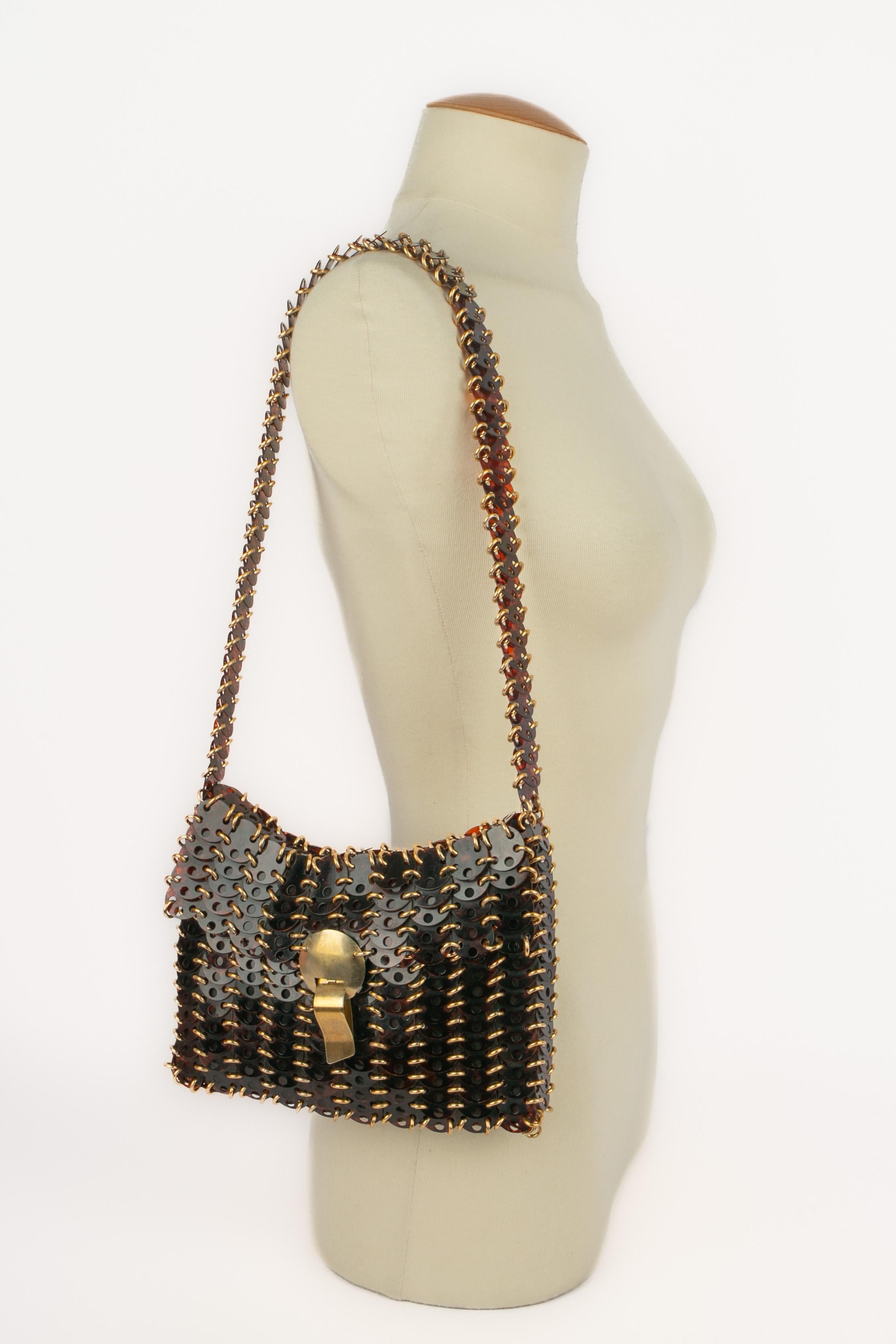 PACO RABANNE - Tortoiseshell-color celluloid pastille bag with golden metal rings and fastener.

Condition:
Good condition

Dimensions:
Length: 22 cm - Height: 15 cm - Depth: 2 cm - Handle: 67 cm

SKU:S219


