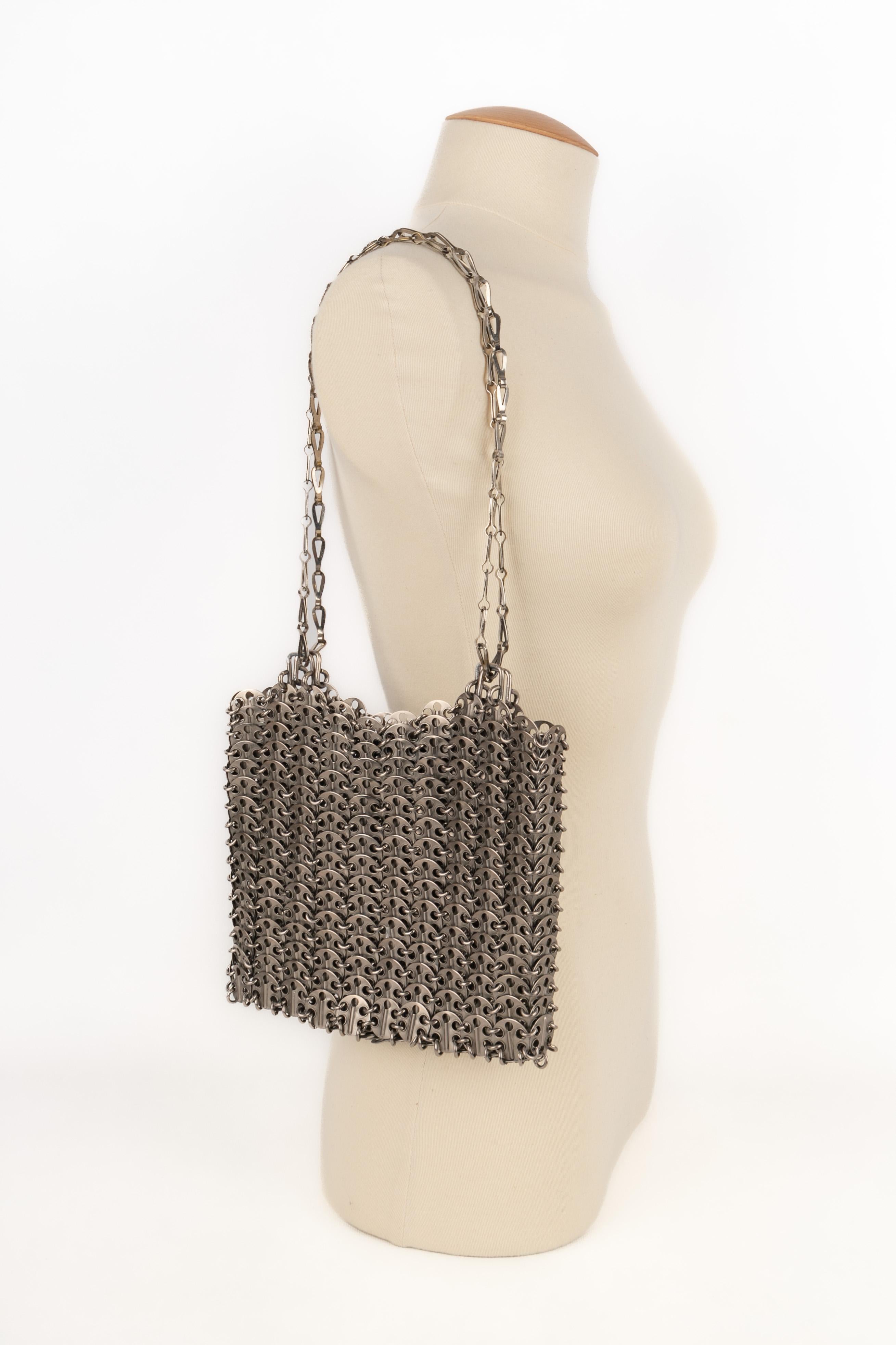 PACO RABANNE - (Made in France) Silvery metallic pastille bag. A 1969 design.

Condition:
Very good condition

Dimensions:
Length: 22 cm - Height: 13 cm - Depth: 2 cm - Handle length: 55 cm

SKU:S219