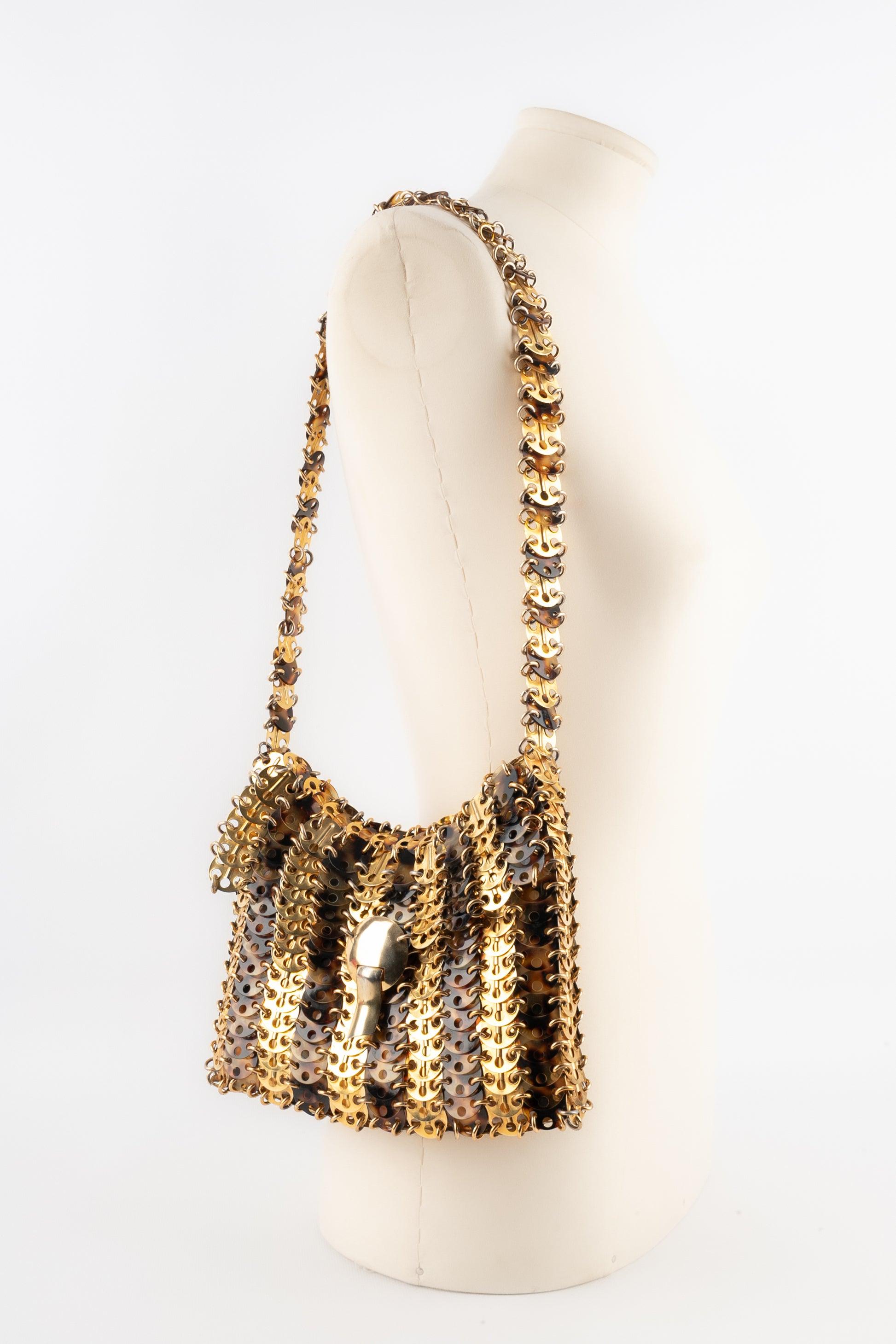 Paco Rabanne - (Made in France) Bag made of golden metal pastilles and tortoiseshell celluloid pastilles assembled with rings. 1969 design.

Additional information:
Condition: Very good condition
Dimensions: Height: 17 cm - Width: 23 cm - Handle: 67