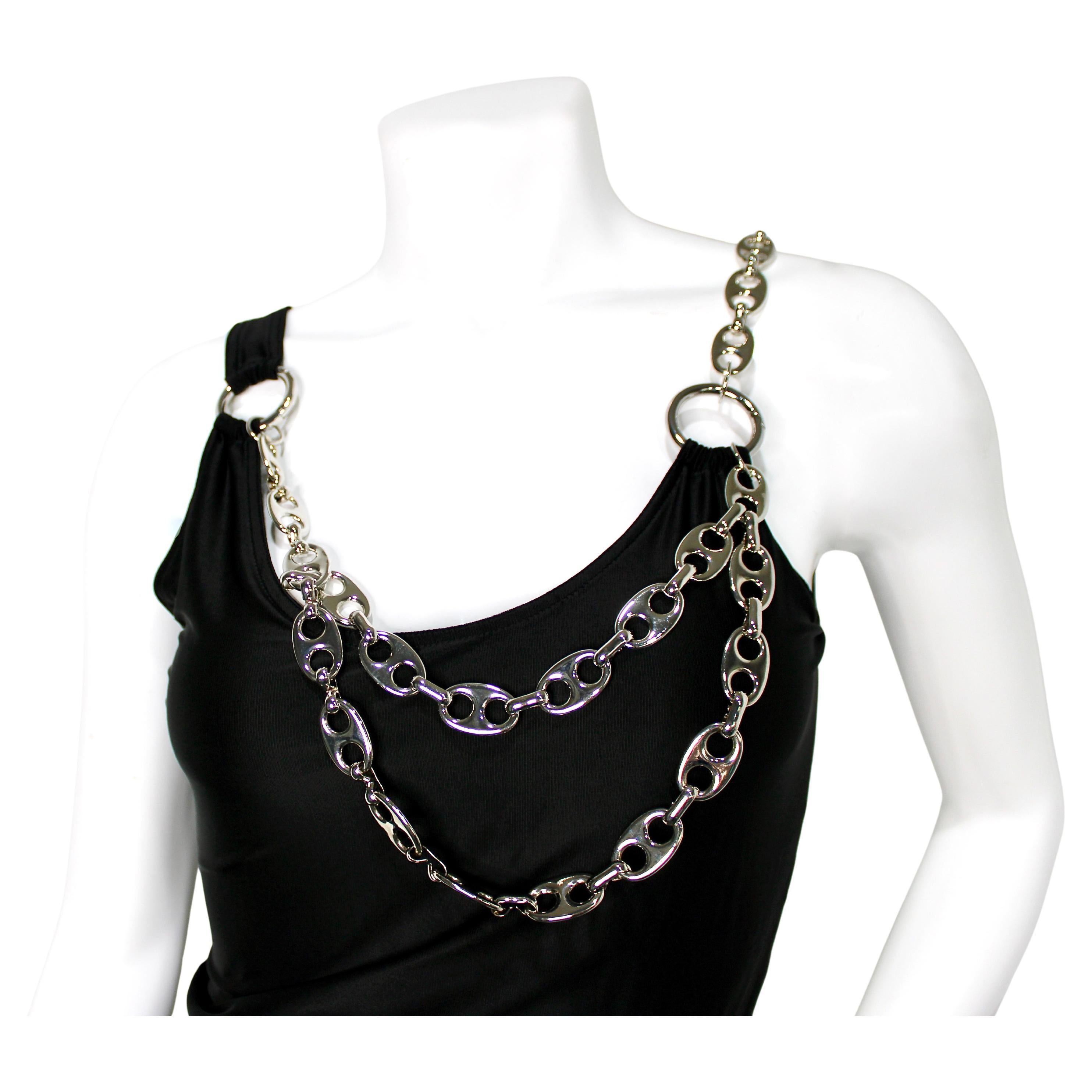 La mini robe ornée de chaînes noires et argentées de Paco Rabanne est une pièce audacieuse et innovante qui capture l'esthétique futuriste caractéristique de la marque. Fabrice en jersey noir élégant, cette mini robe est ornée de chaînes argentées