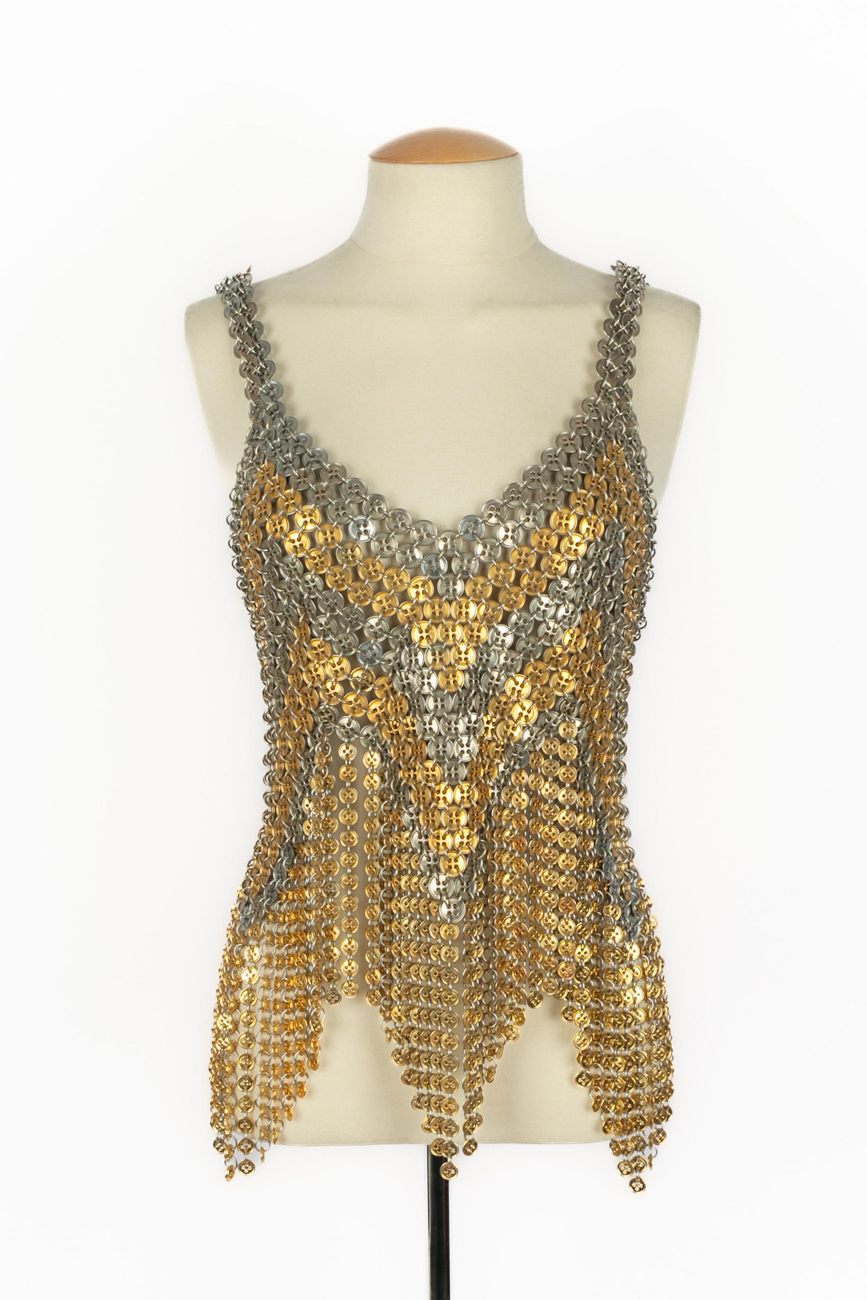 PACO RABANNE - Top de botones metálicos plateados y dorados, y con pequeños flecos de botones dorados. No se indica la talla, se ajusta a una 34FR/36FR. Pieza no firmada de la colección de Alta Costura Primavera-Verano de 1970.

Estado:
Muy buen