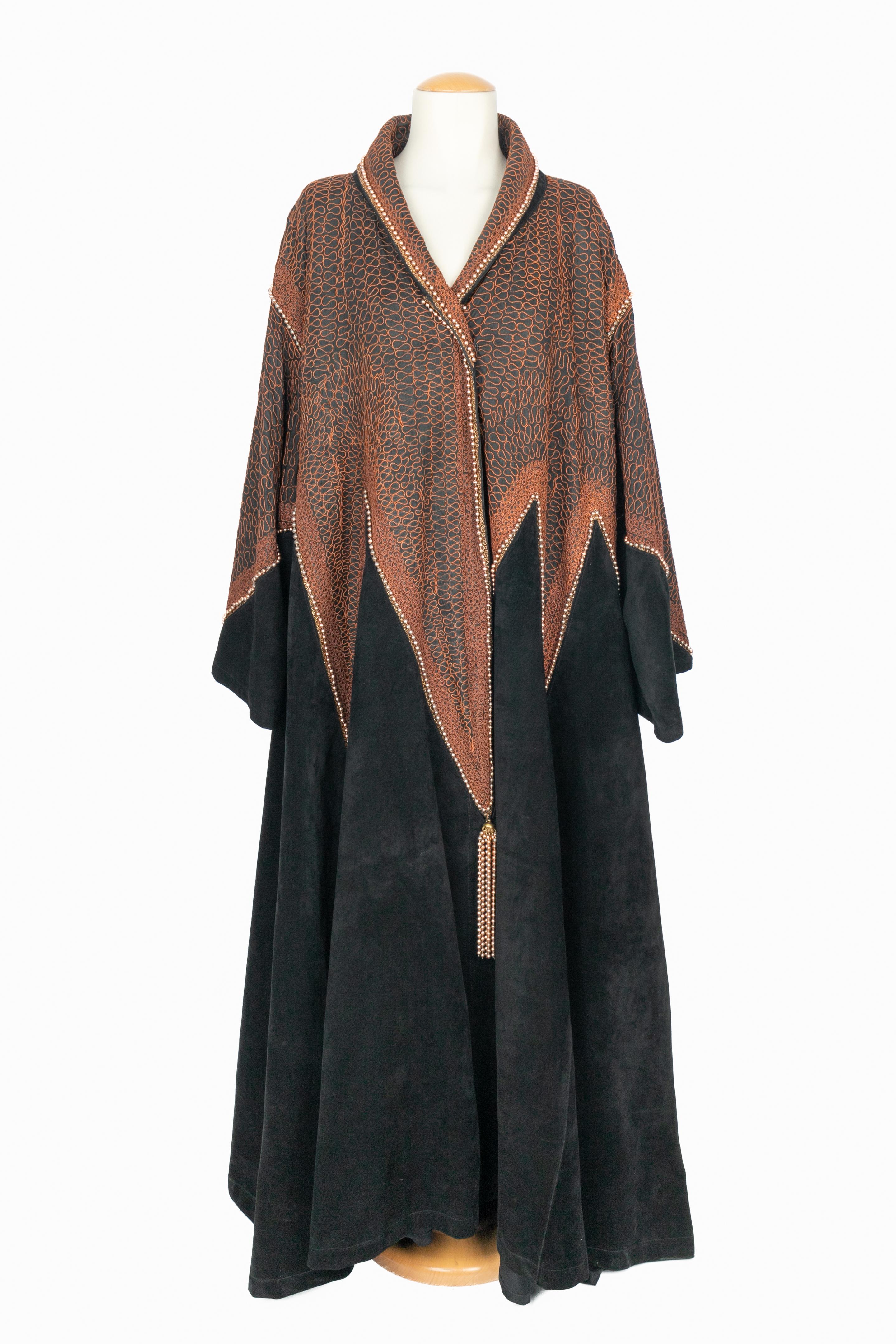 PACO RABANNE - Langer schwarzer Innenledermantel, bestickt mit goldbraunen Borten und verziert mit goldenen Perlen und passenden Pompons. Keine Größenangabe, es passt ein 42FR. Prototyp aus der Collection'S Fashion Show 1982-1983, der Paco Rabanne