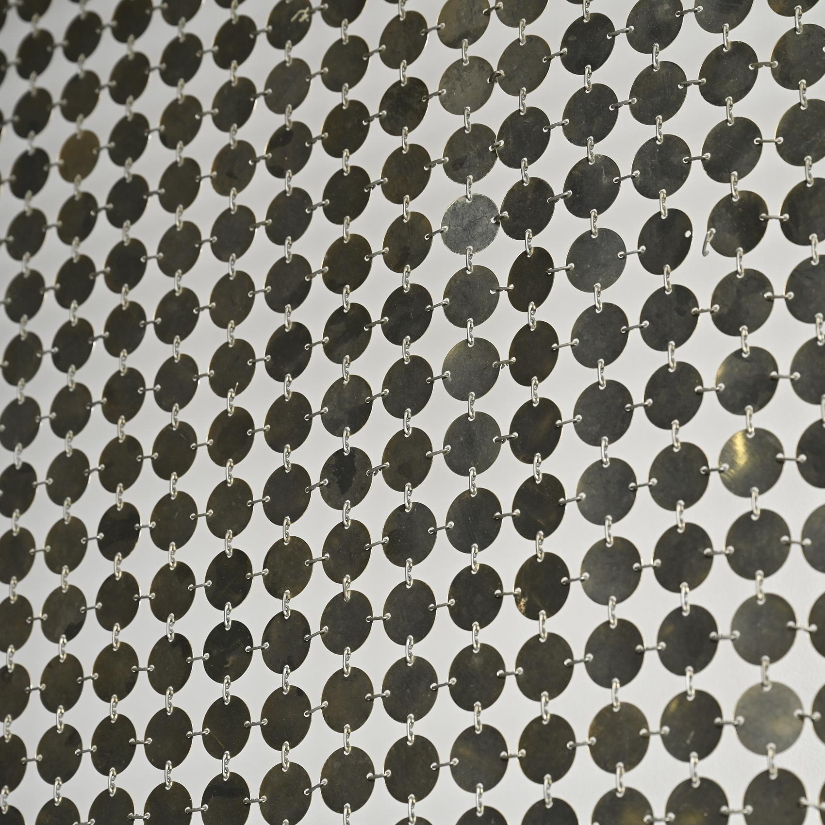 
 El modelo Rideau d'Espace fue diseñado por Paco Rabanne hacia 1970.

Fabricado con discos redondos de plástico cromado unidos por pequeños anillos metálicos, refleja los experimentos del modisto con materiales industriales y modulares aplicados a
